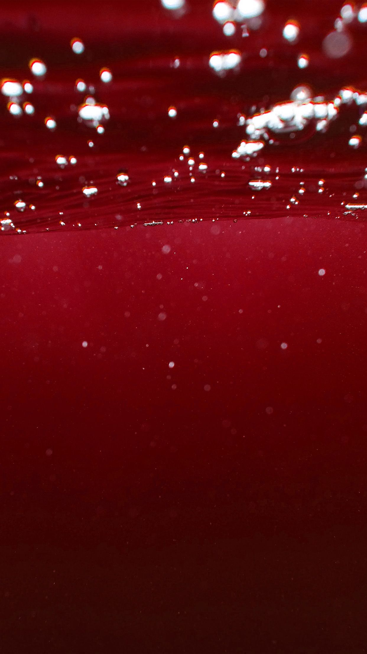 A close up of a red liquid with bubbles in it - Dark red, underwater