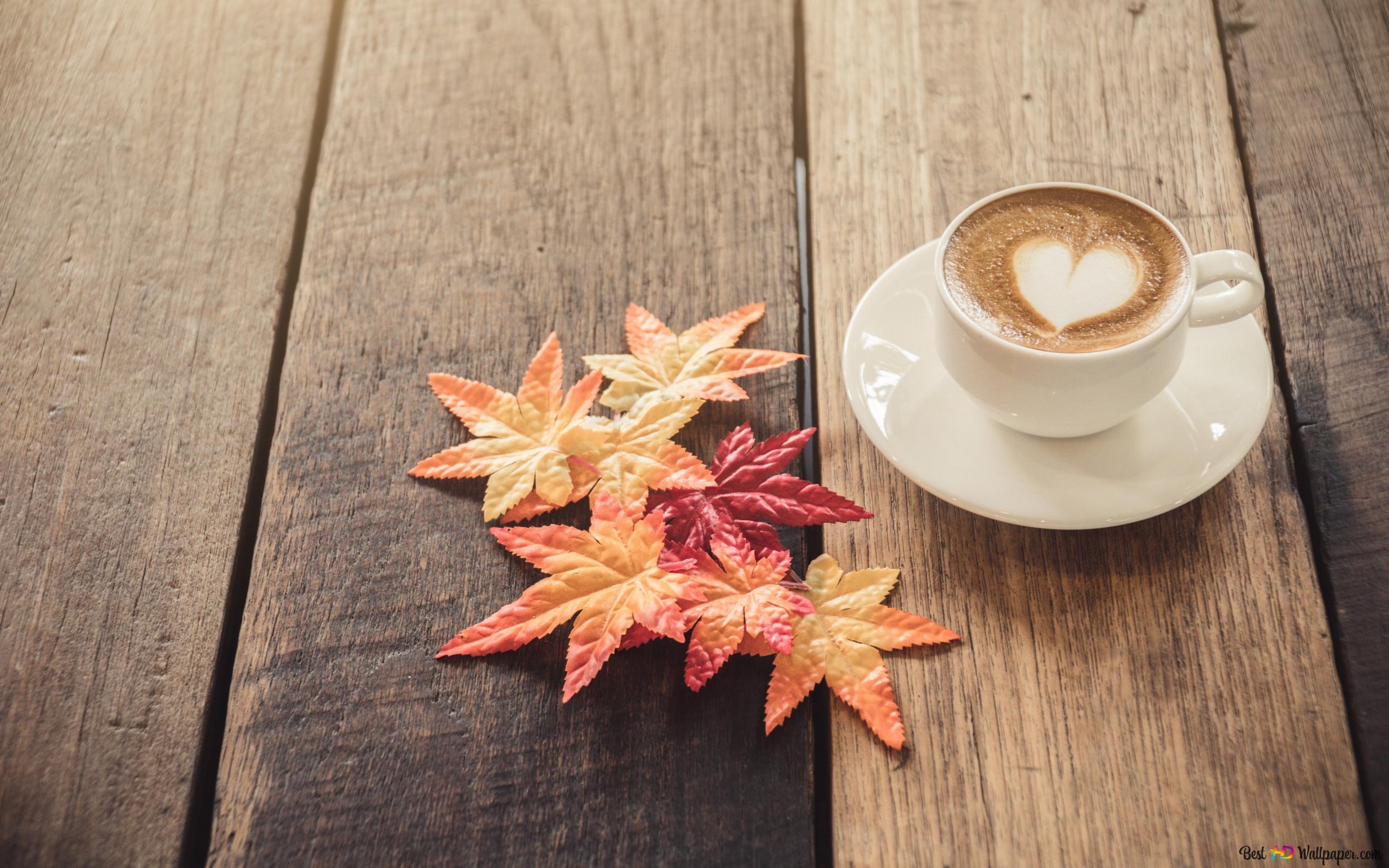 A cup of coffee with heart shape and autumn leaves on a wooden table. - Coffee