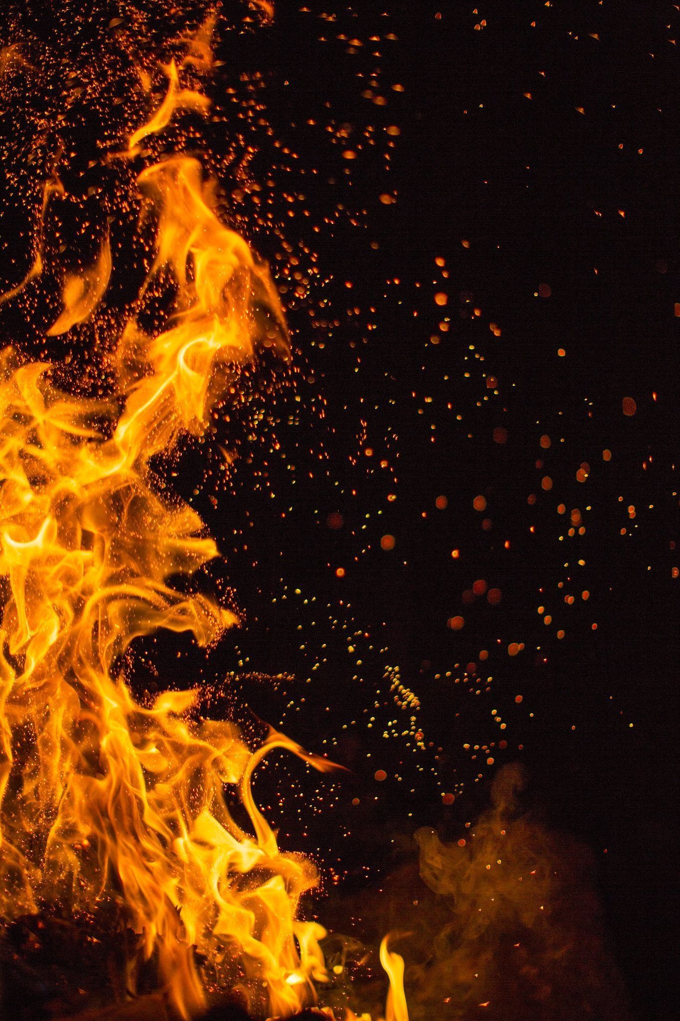 A close up of a fire with sparks flying - Fire, flames
