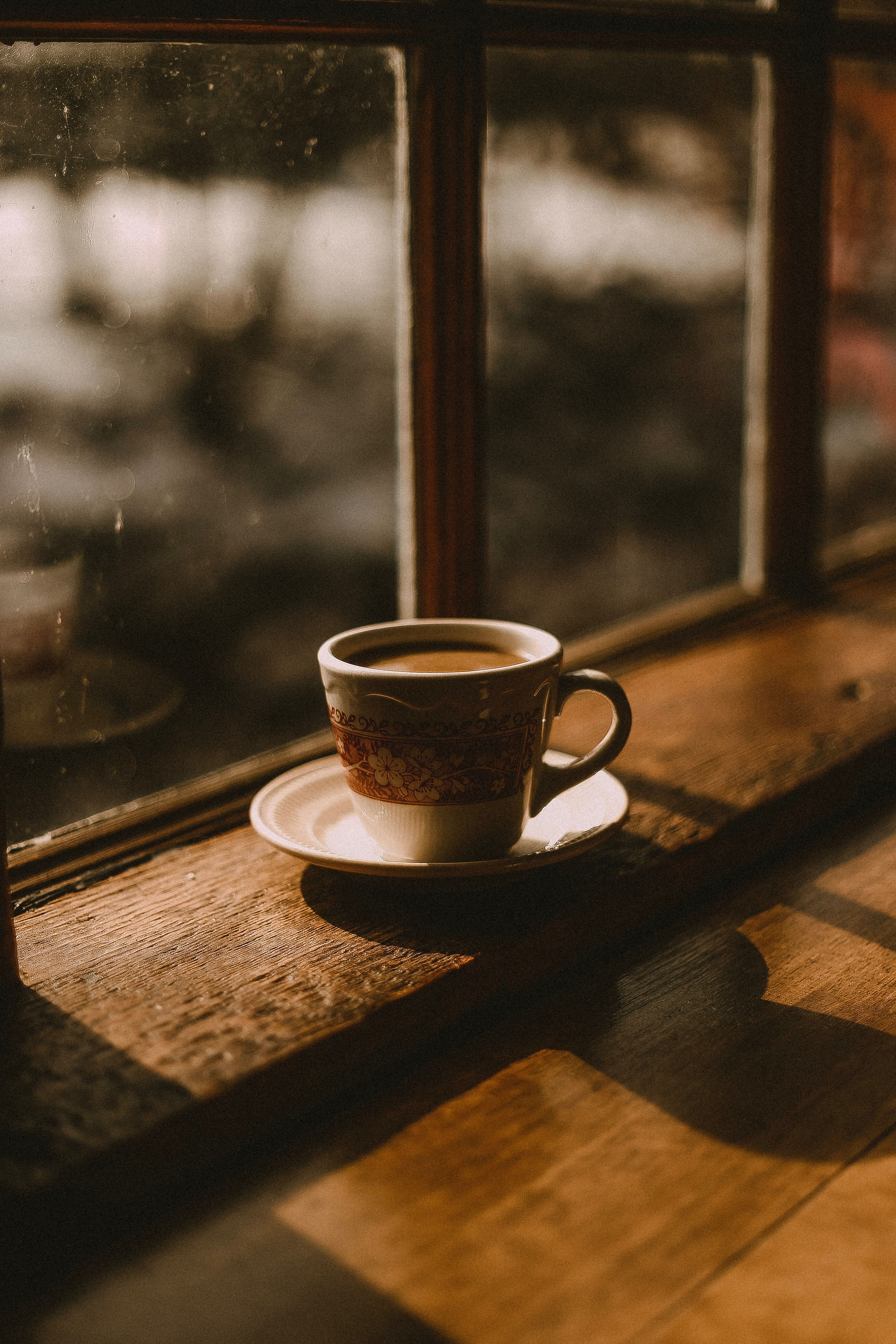 A cup of coffee sitting on the windowsill - Coffee