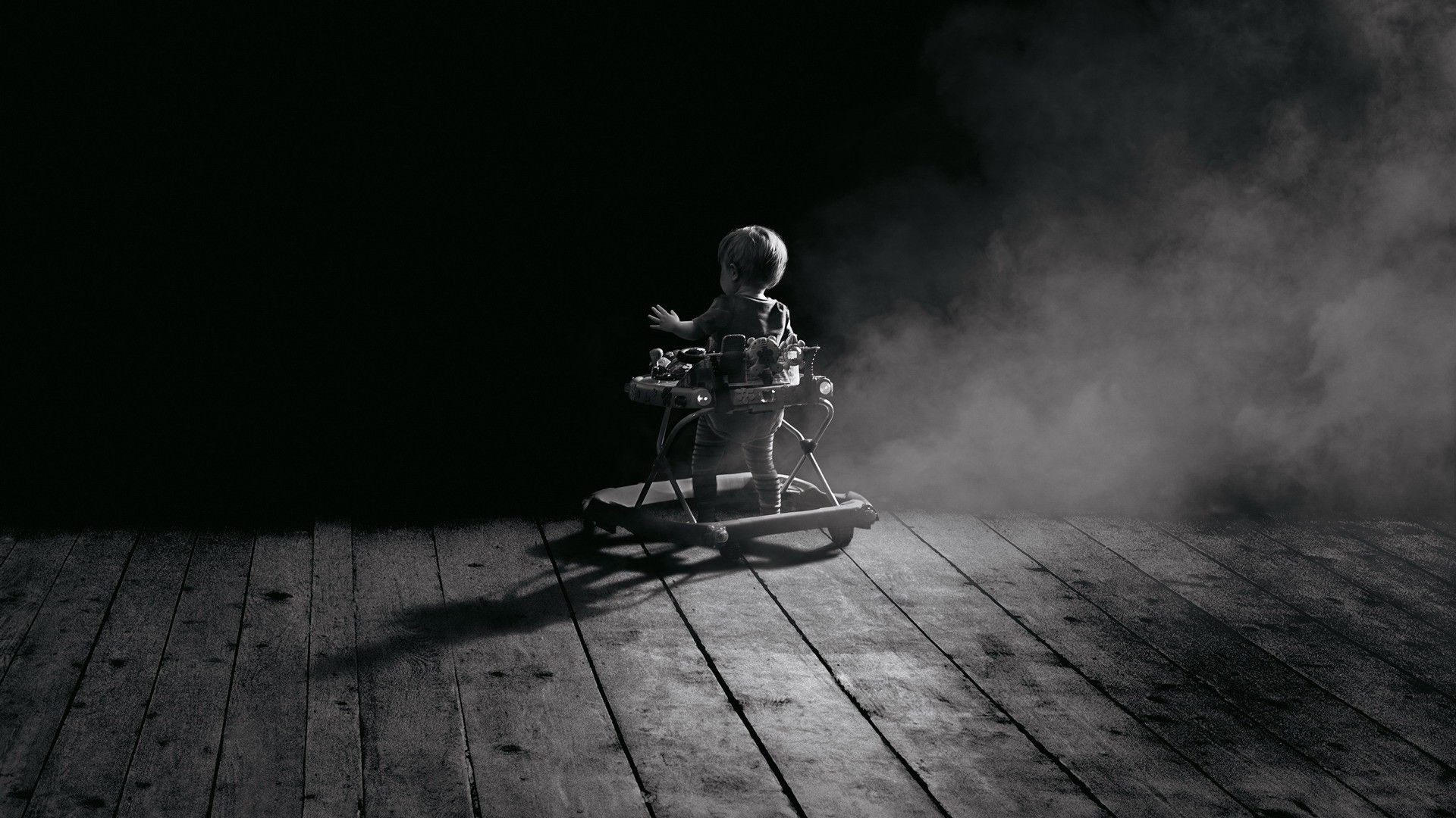 A small child in a walker in a dark room with smoke - Horror