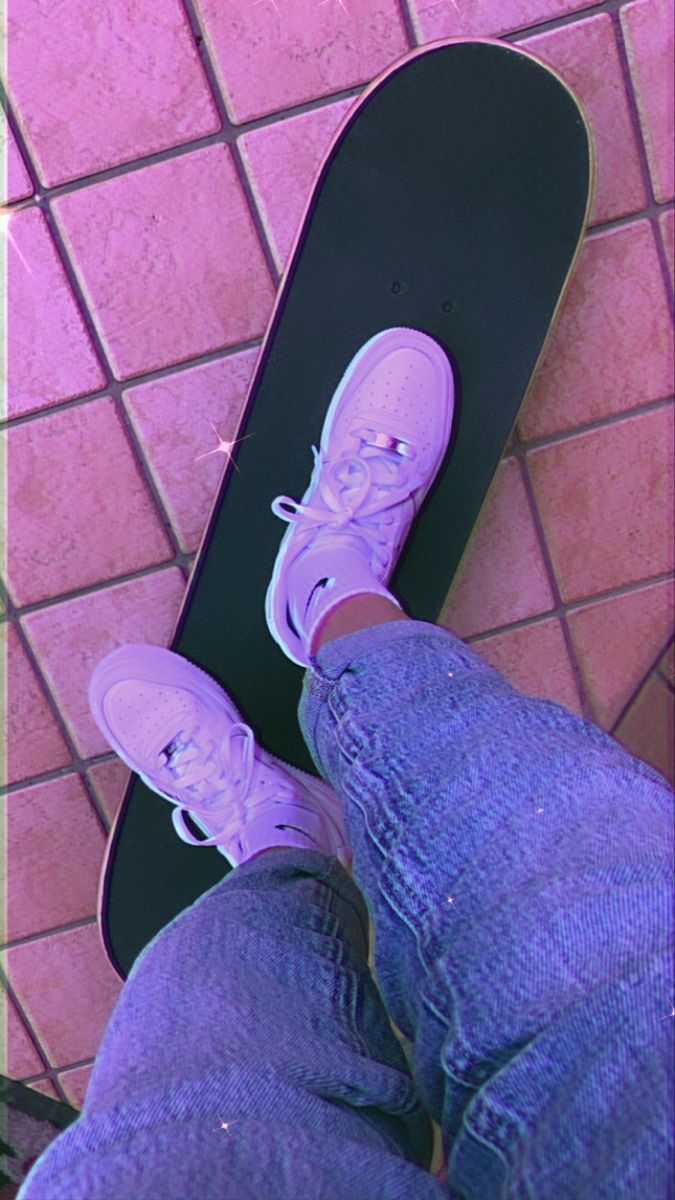 A person wearing pink shoes standing on a skateboard. - Skate, skater