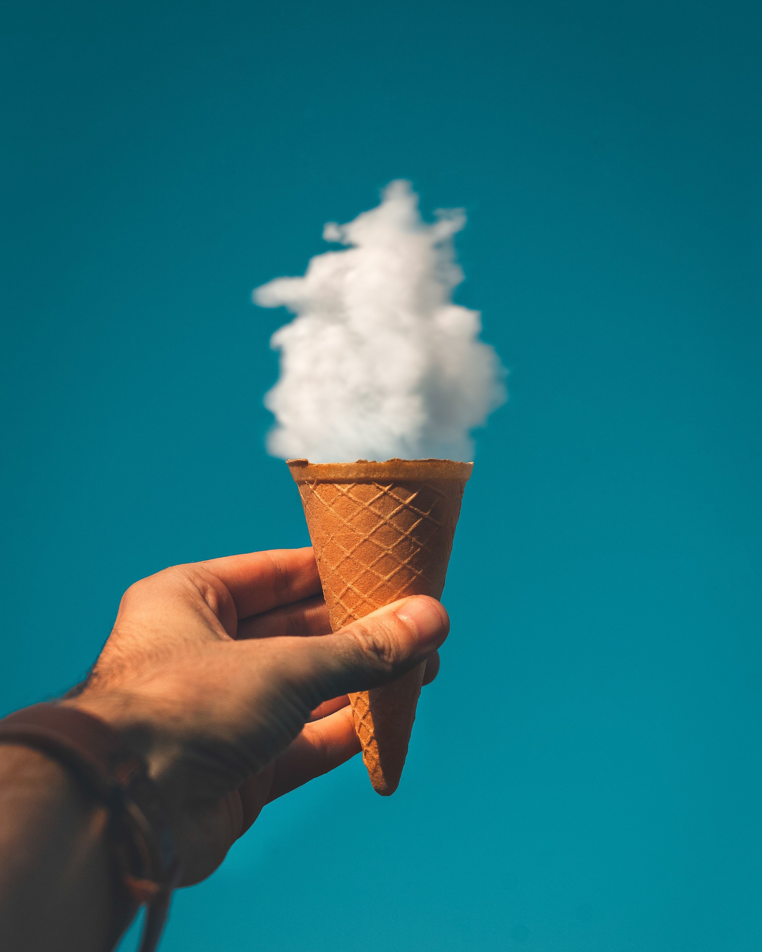 A person holding an ice cream cone with smoke coming out of it - Ice cream