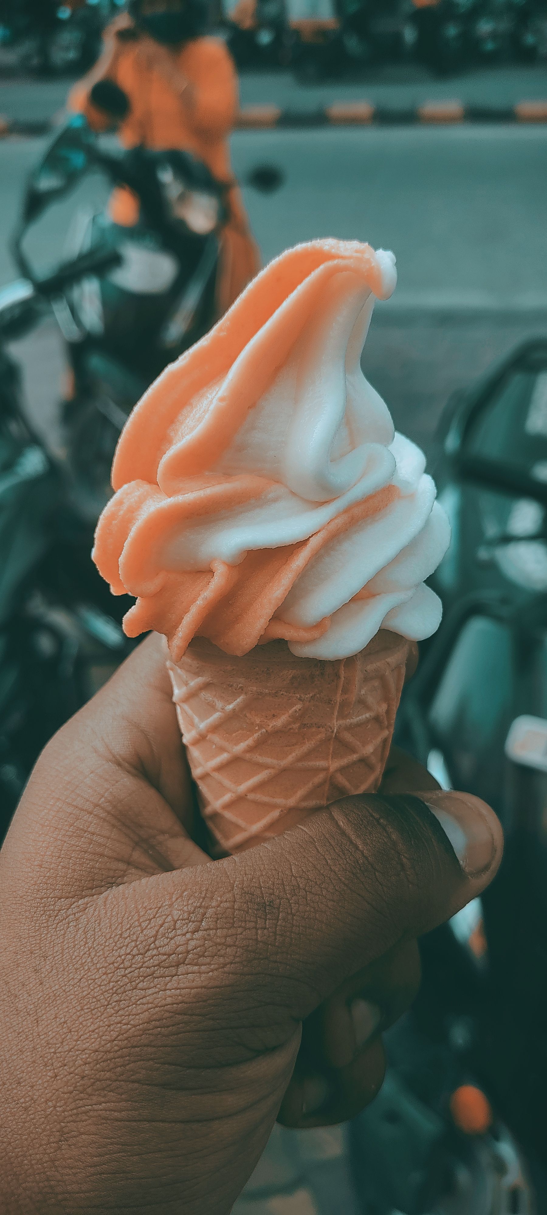 A person holding an ice cream cone in their hand - Ice cream