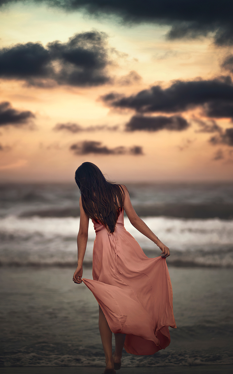 A woman in a flowing dress walking on the beach - Beach