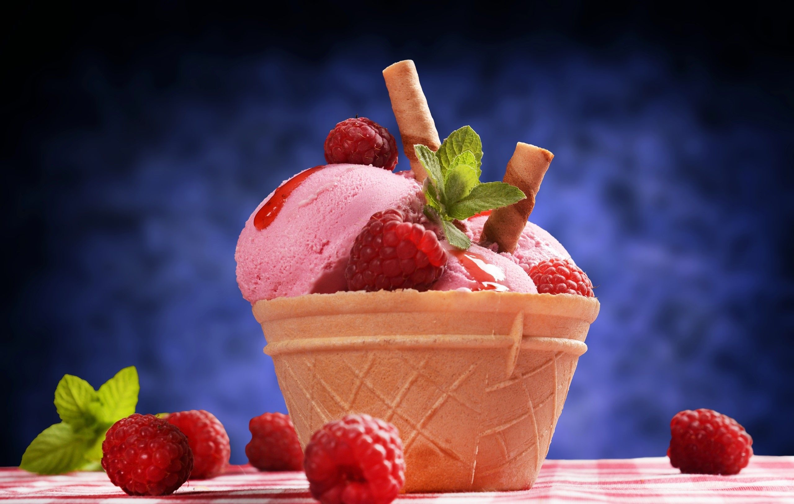A cone of raspberry ice cream with mint leaves and wafers - Ice cream