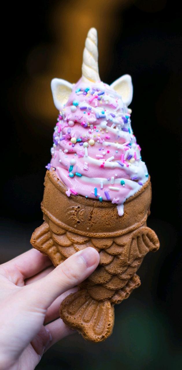 A person holding an ice cream cone with sprinkles - Ice cream