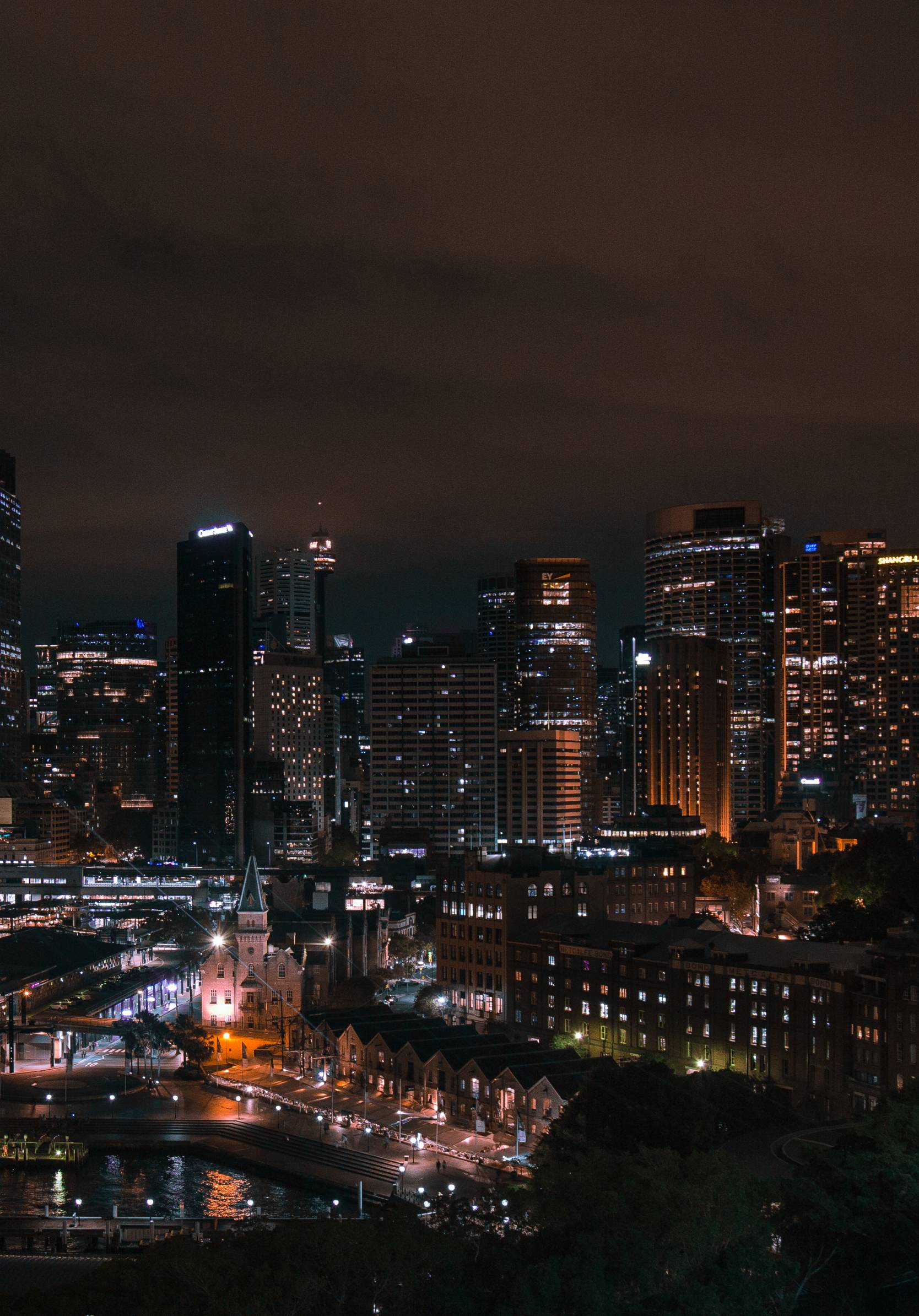 A city skyline at night with lights on - City