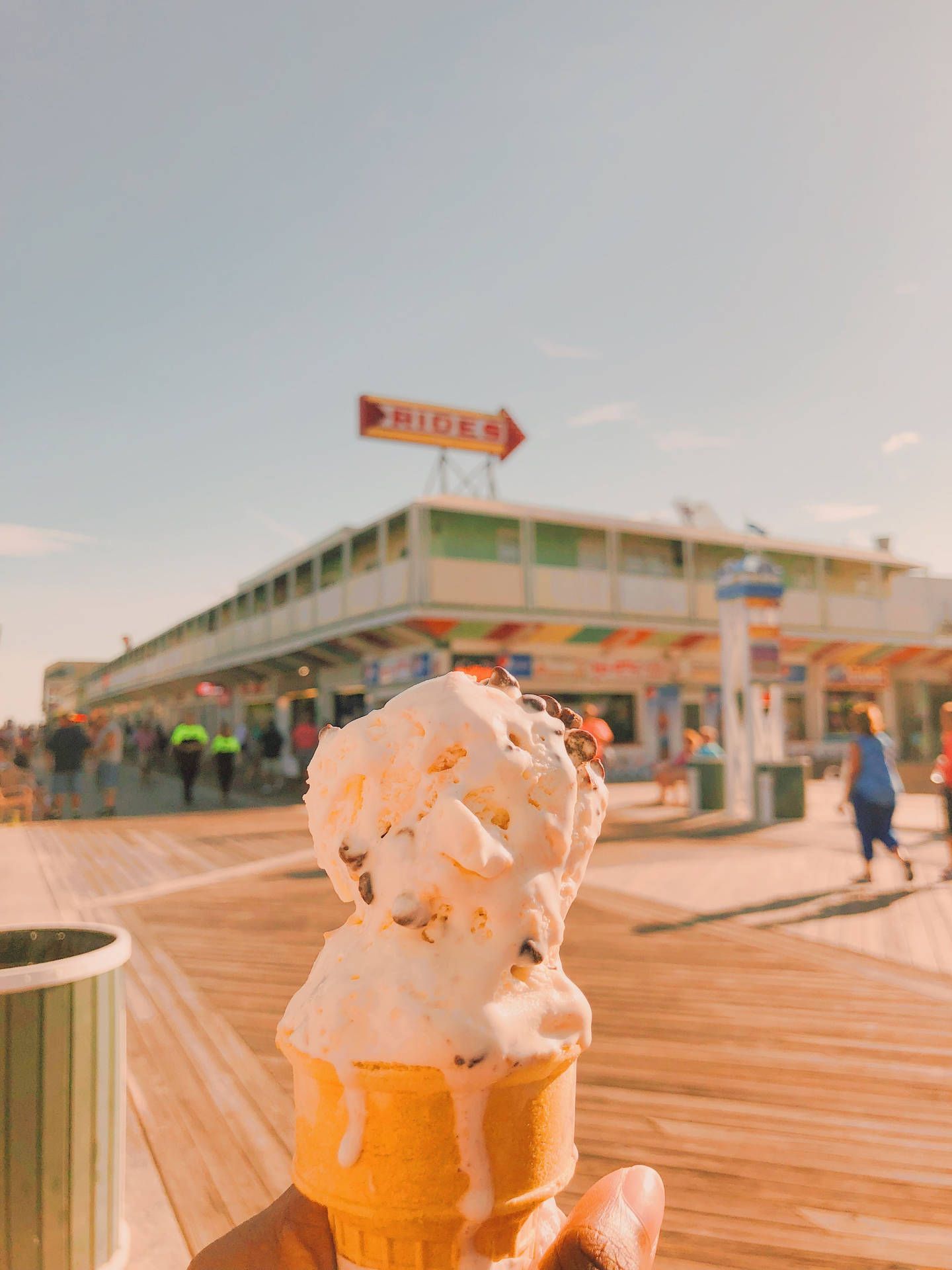 A person holding an ice cream cone on the beach - Ice cream