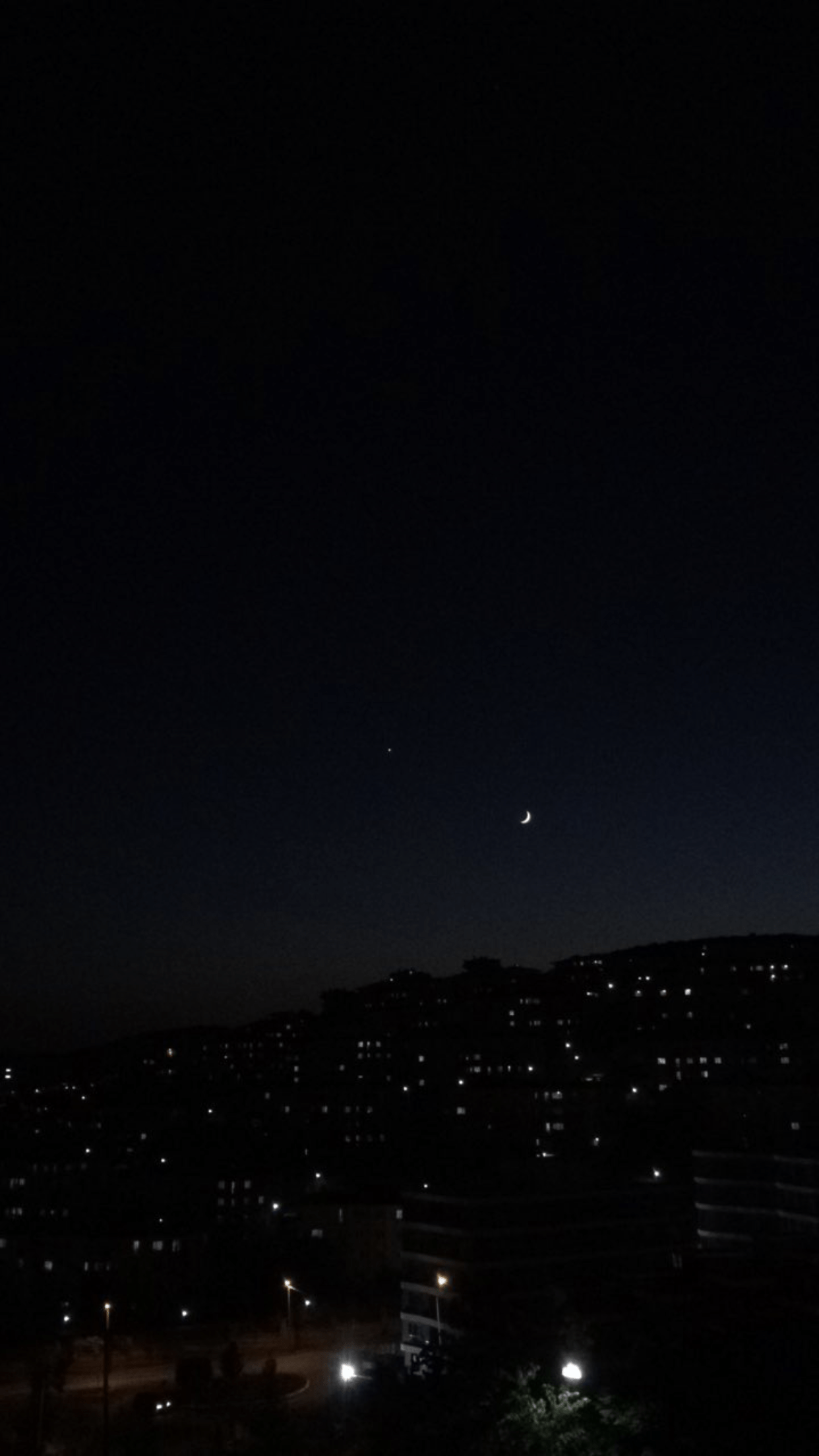 Nighttime view of the moon and venus in the sky over a city - Night