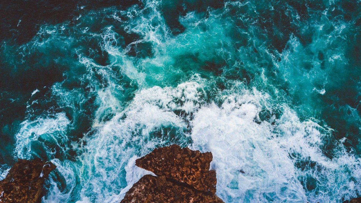 Aerial view of the ocean waves crashing against the rocks - Ocean