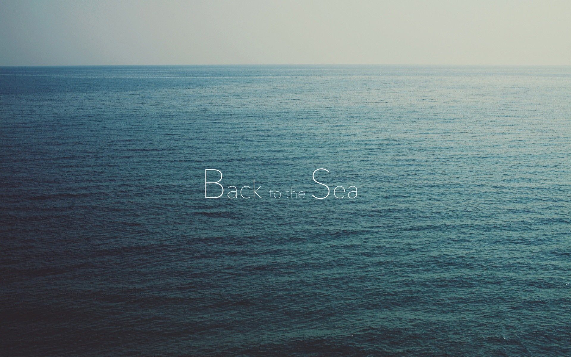 A blue ocean with the words back in sea - Ocean