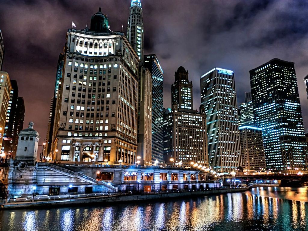 The Chicago River at night with the city lights reflecting in the water. - Chicago
