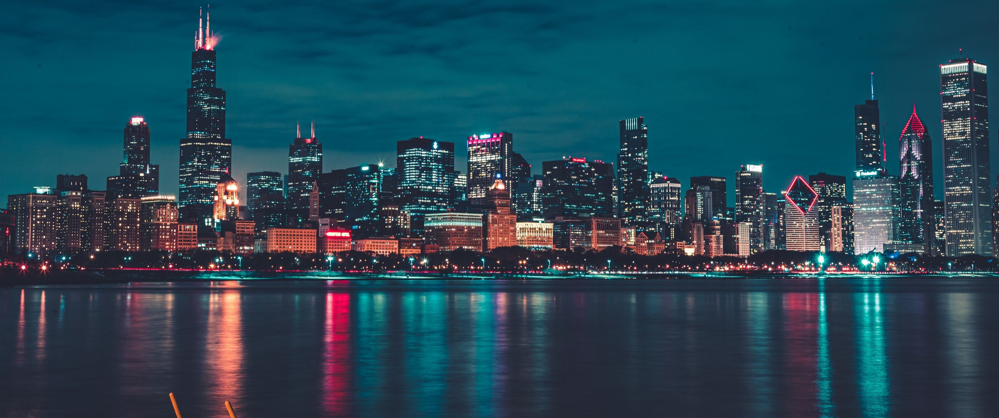 A city skyline at night with lights reflecting in the water - Chicago