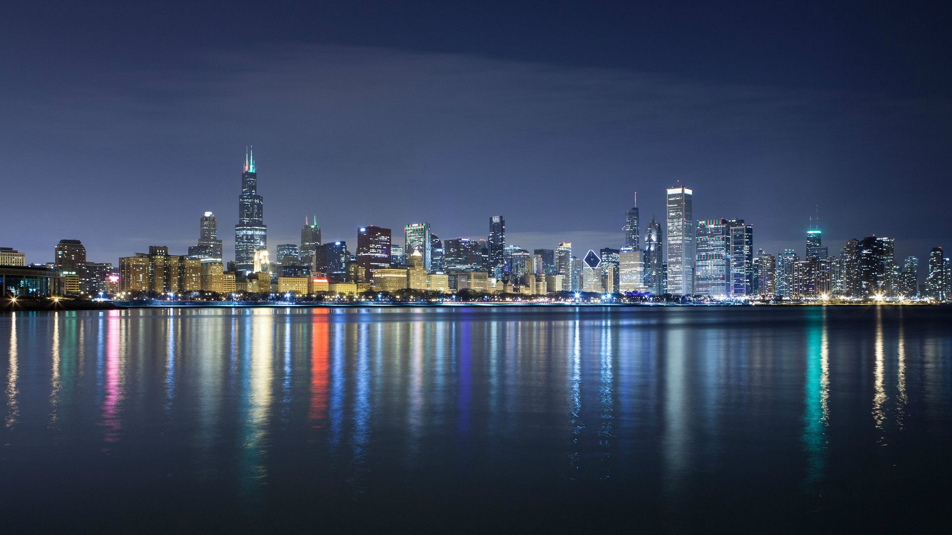 A city skyline at night with reflections in the water - Chicago