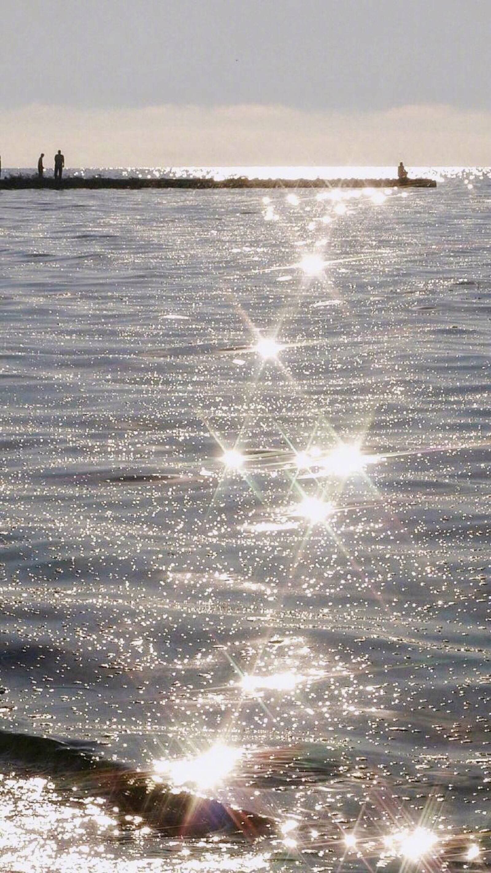 The sun reflecting off the water on a beach. - Glitter, bling, sunshine
