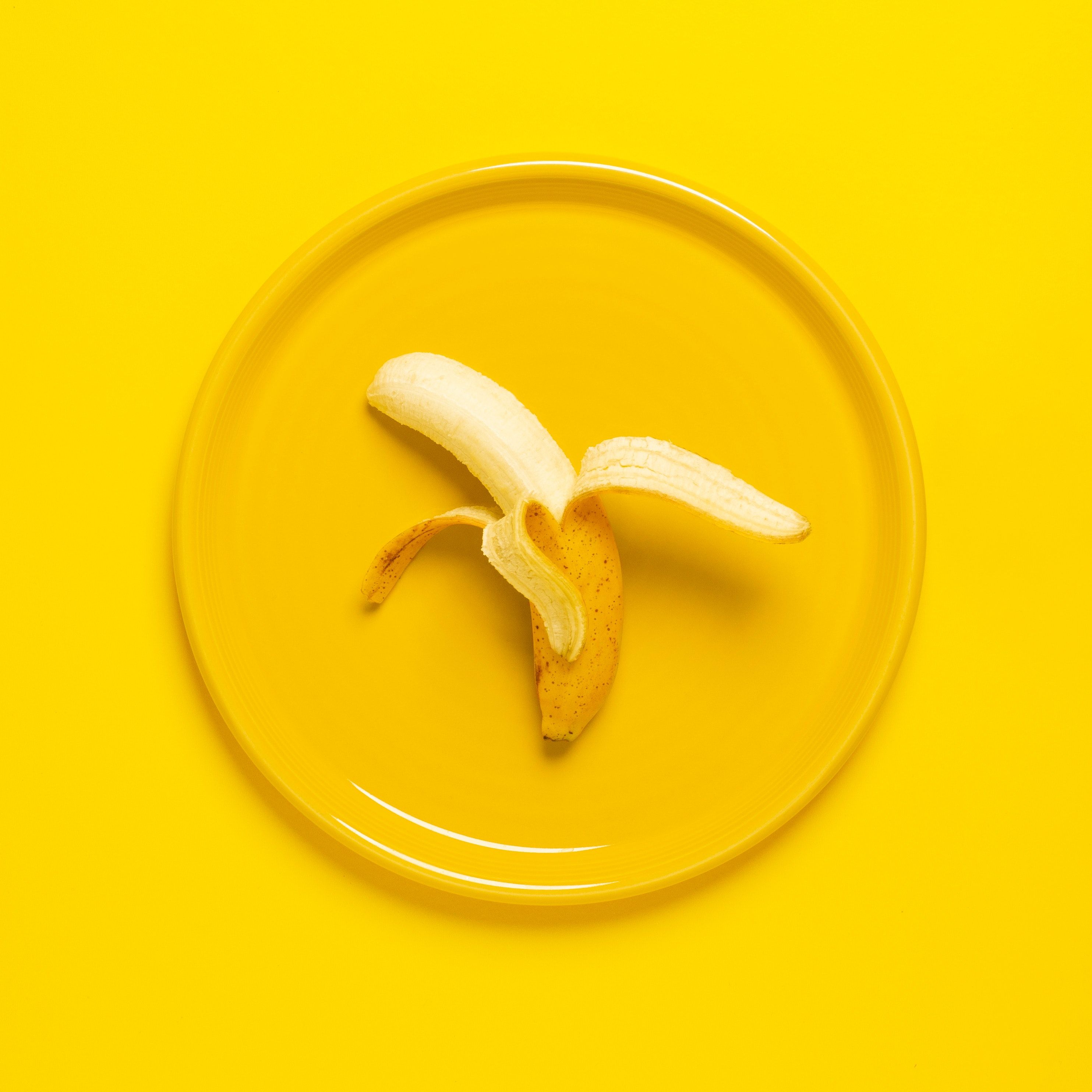 A banana sitting on top of an orange plate - Banana