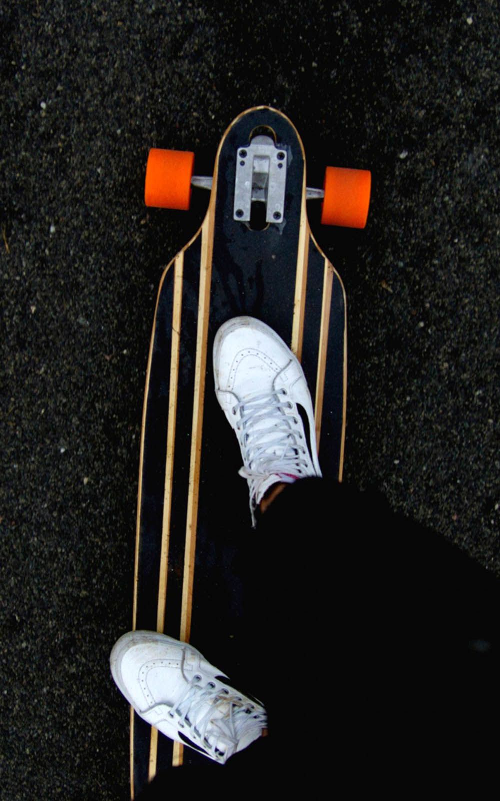 A person's feet are seen resting on a skateboard. - Skate, skater