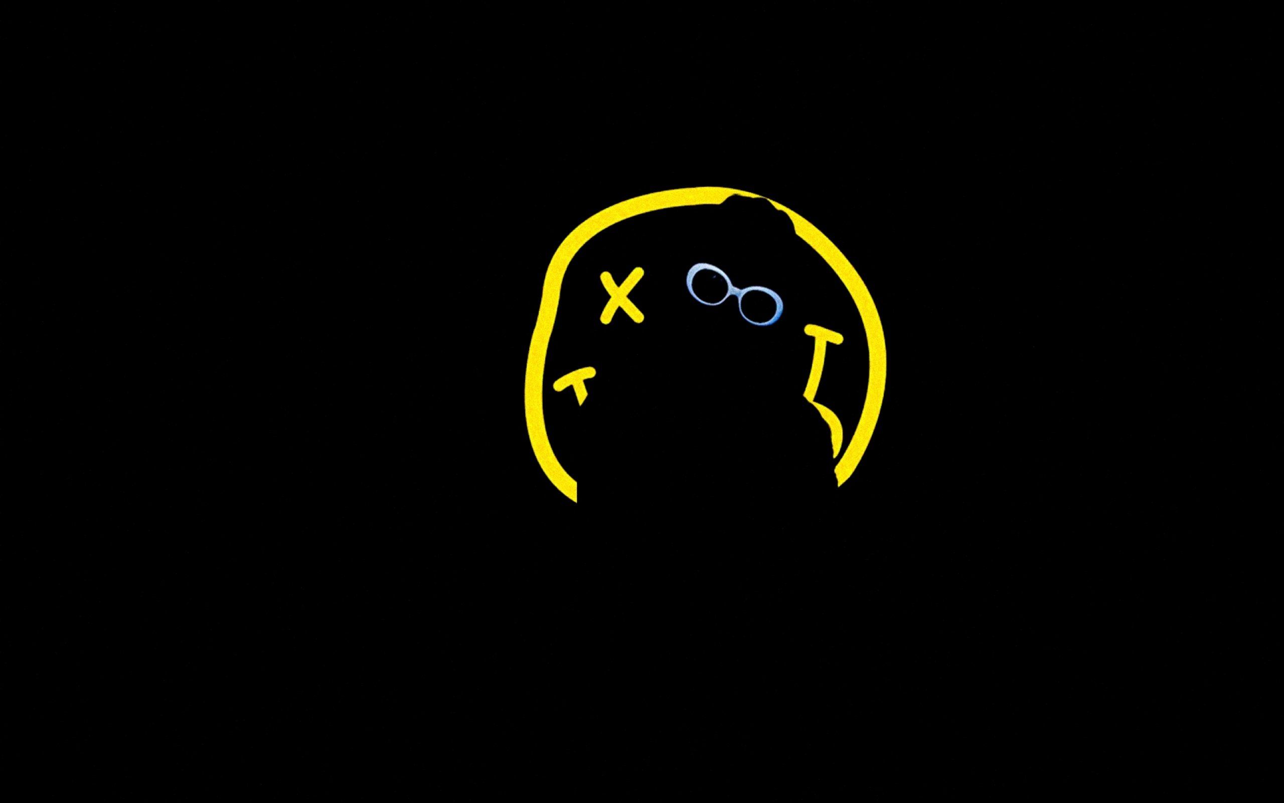 A black background with a yellow smiley face in the center. - Nirvana