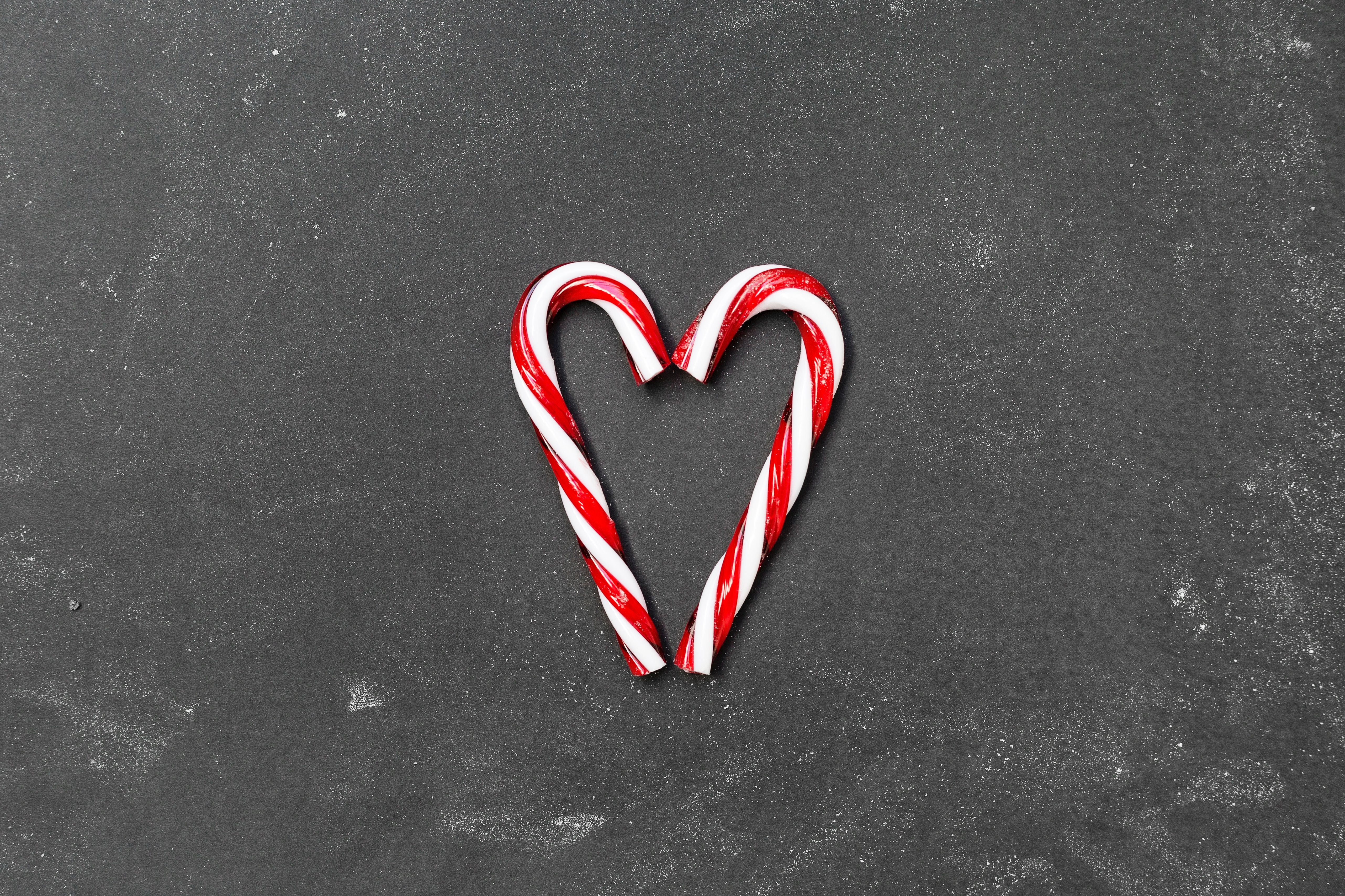 A candy cane shaped heart on top of chalkboard - Candy, candy cane