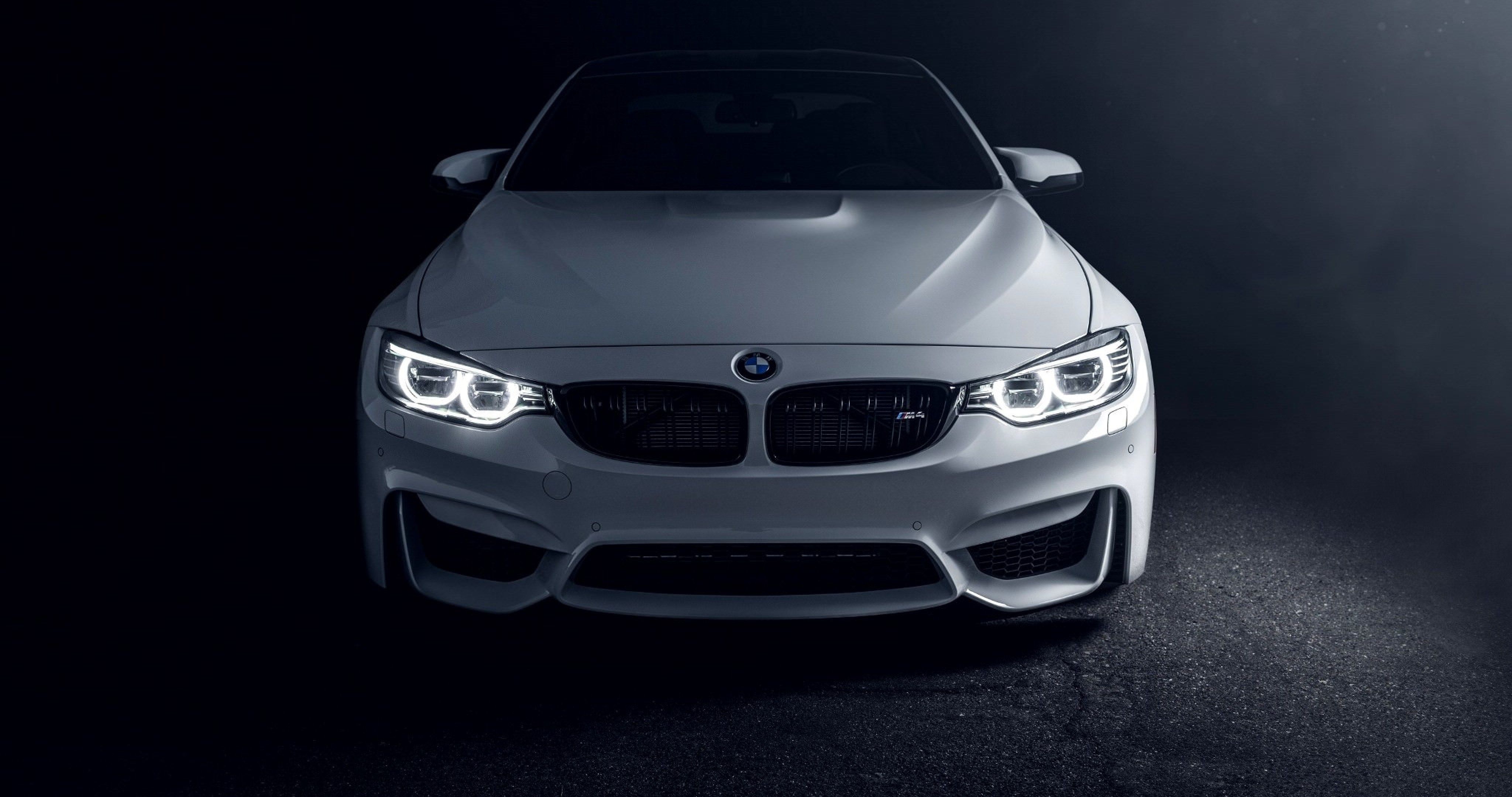 A white bmw car is shown in the dark - BMW