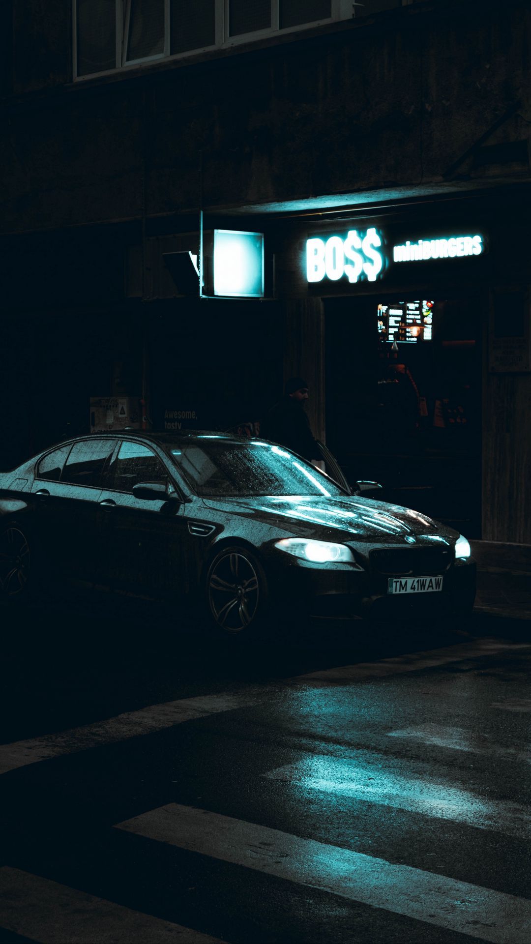 A car parked in front of an illuminated store - BMW