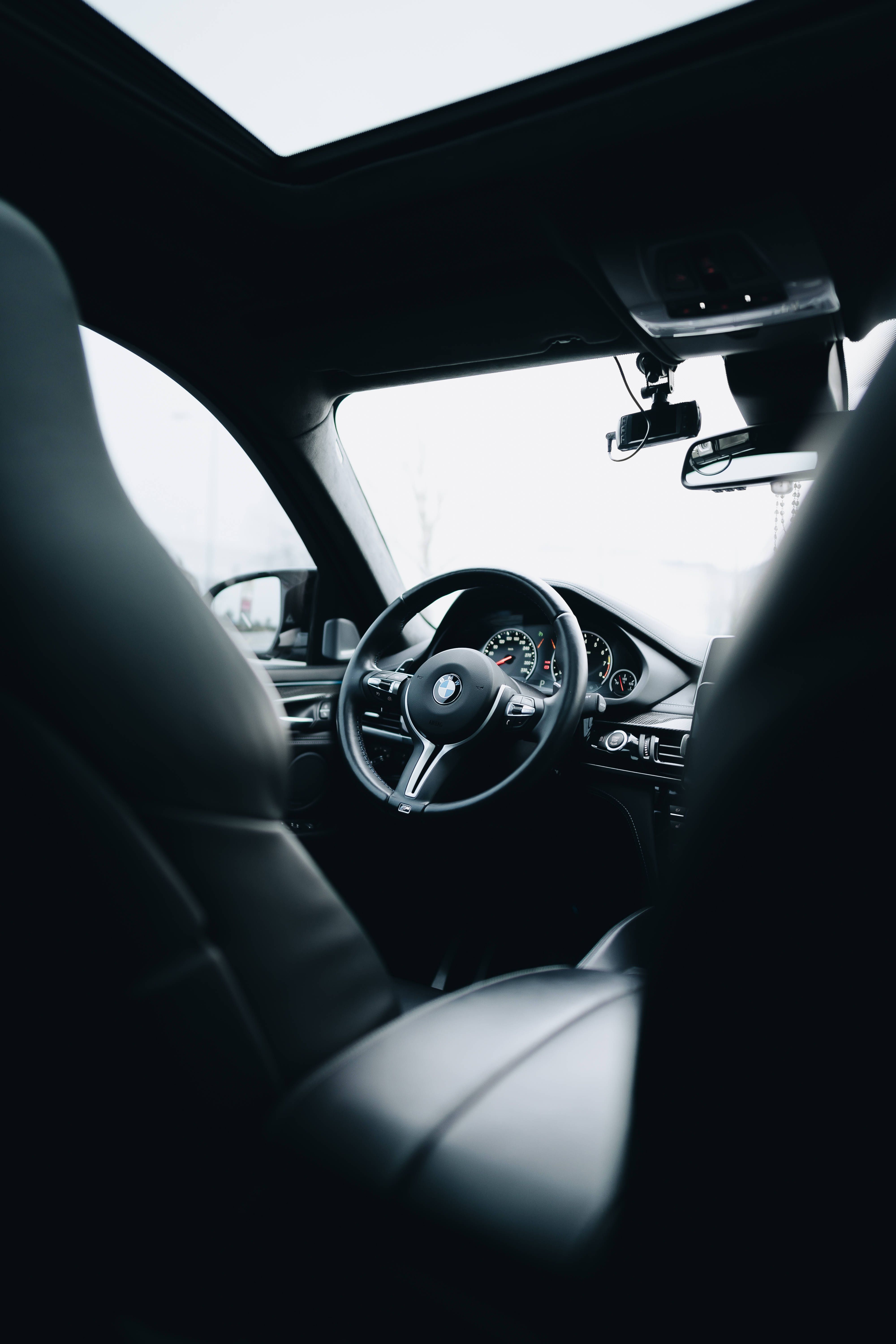 A car interior with the steering wheel and dashboard - BMW