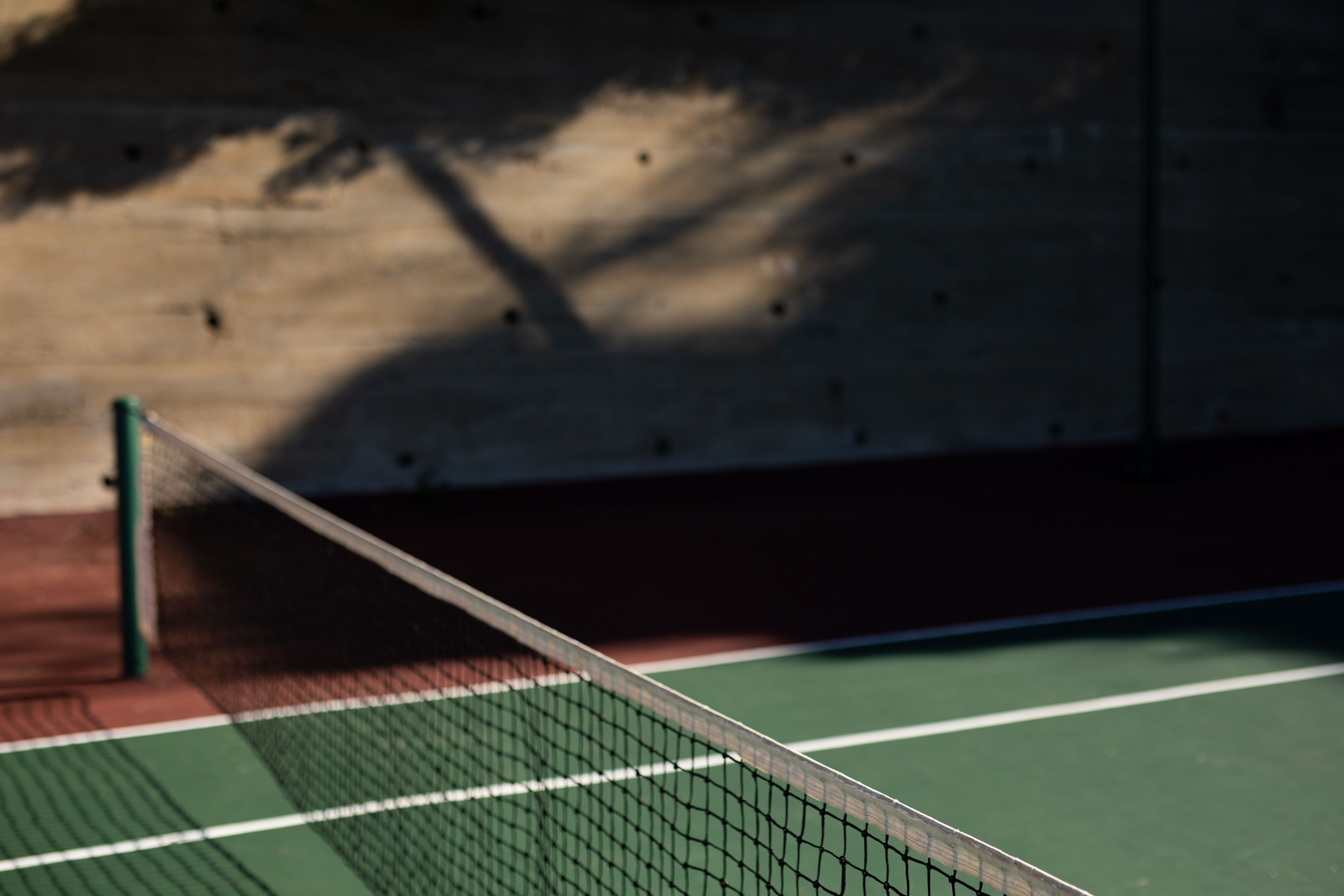 Side view of a tennis court on a sunny day Photo from PikWizard