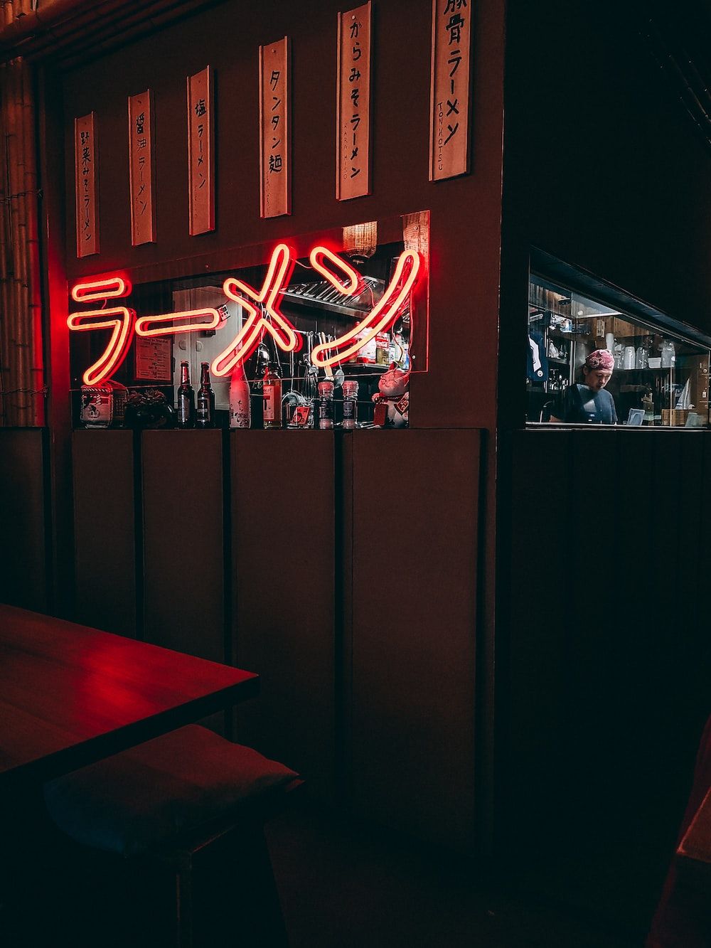 A restaurant with neon lights and tables - Ramen