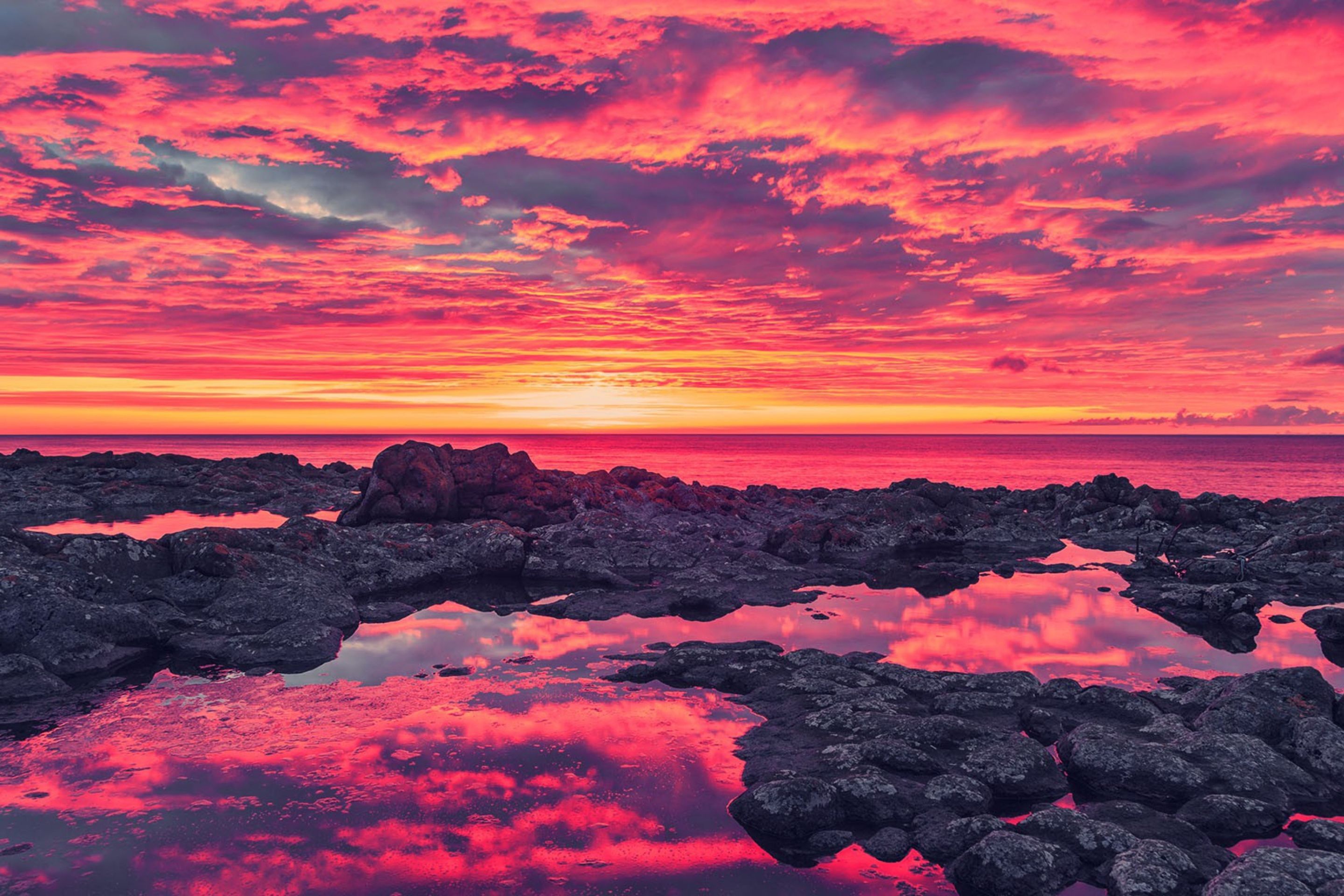 A sunset over the ocean with rocks in it - Sunset