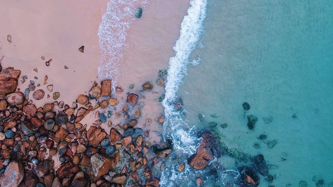 An aerial view of a beach with rocks - Beach, coast