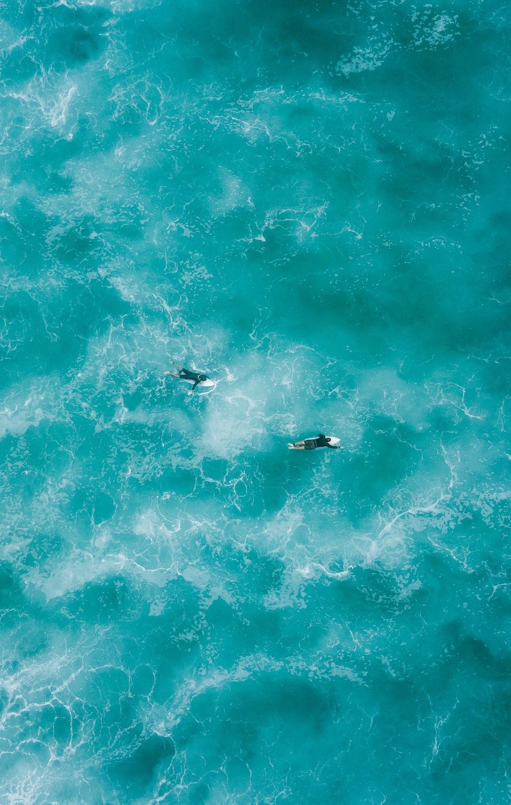 Aerial view of two surfers in the ocean - Surf
