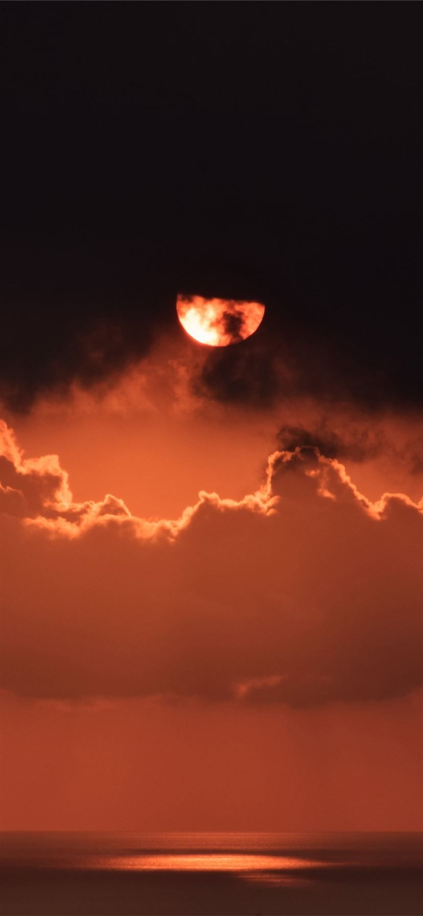 IPhone wallpaper of a red moon rising over the sea with clouds - Sunset, dark orange