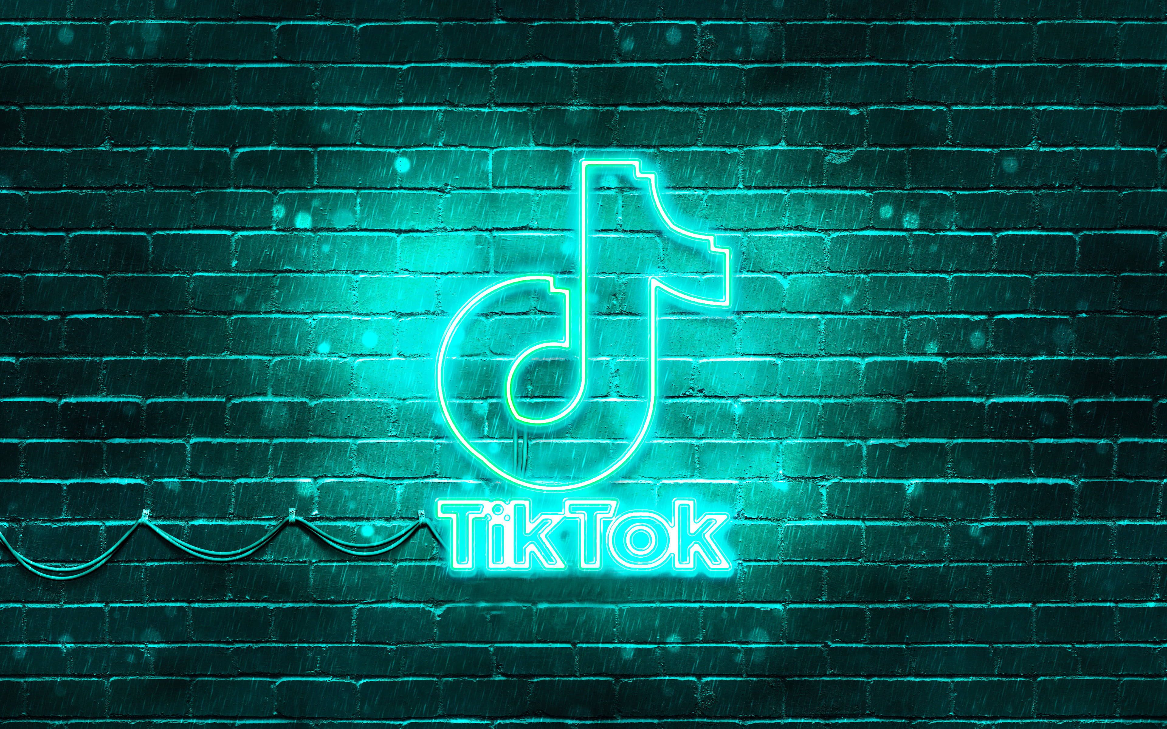 A neon sign of TikTok on a brick wall - Turquoise