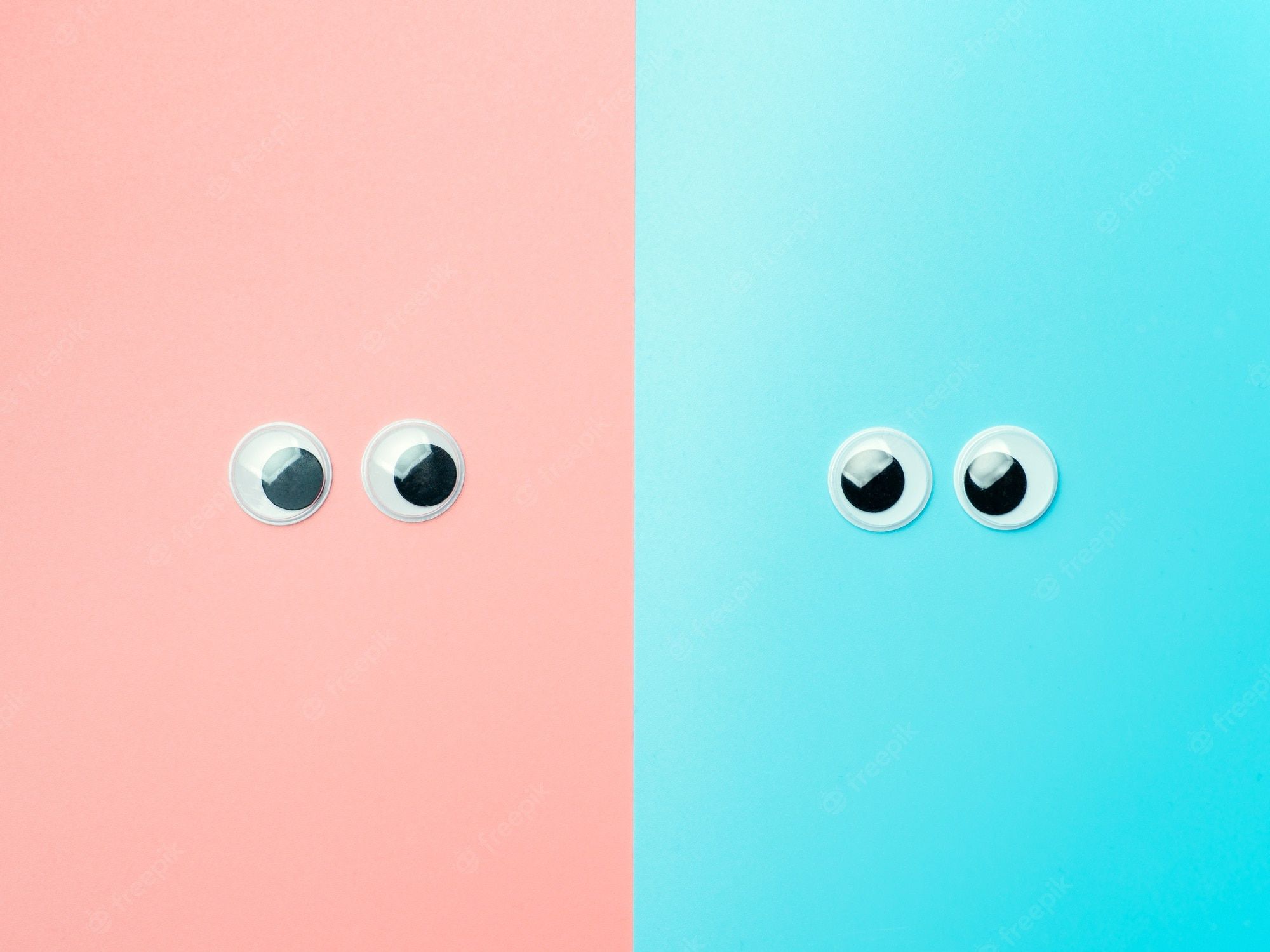 Premium Photo. Googly eyes on blue an pink background. top view or flat lay. plastic toy eyes on turquoise background