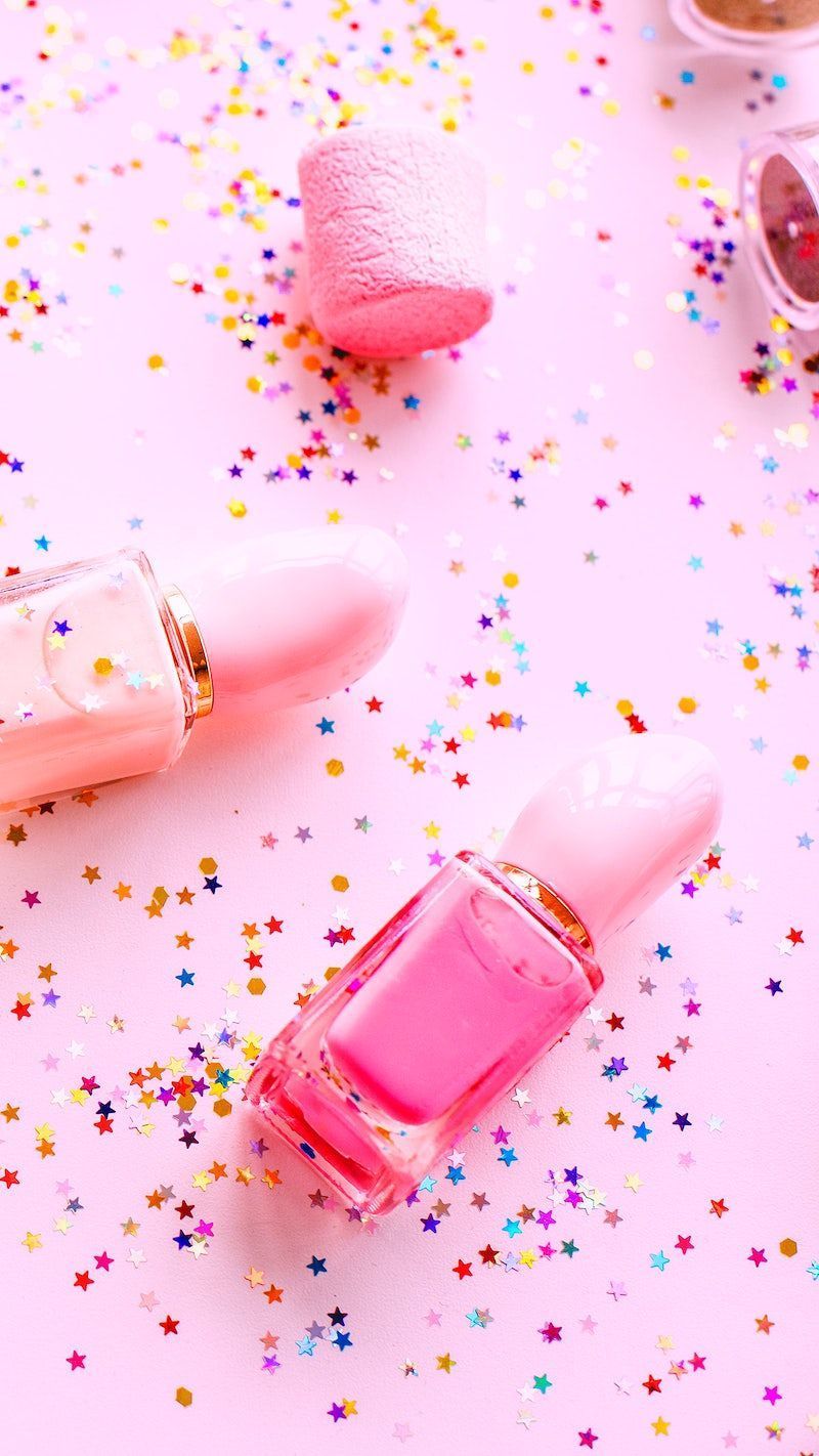 Pink nail polish and lipstick on a pink background with confetti - Nails, makeup