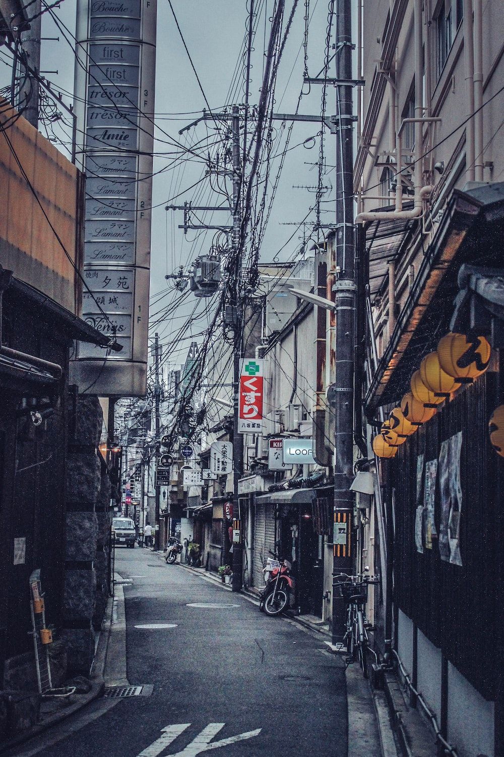A city street with a bike parked on the side of a building. - Japan