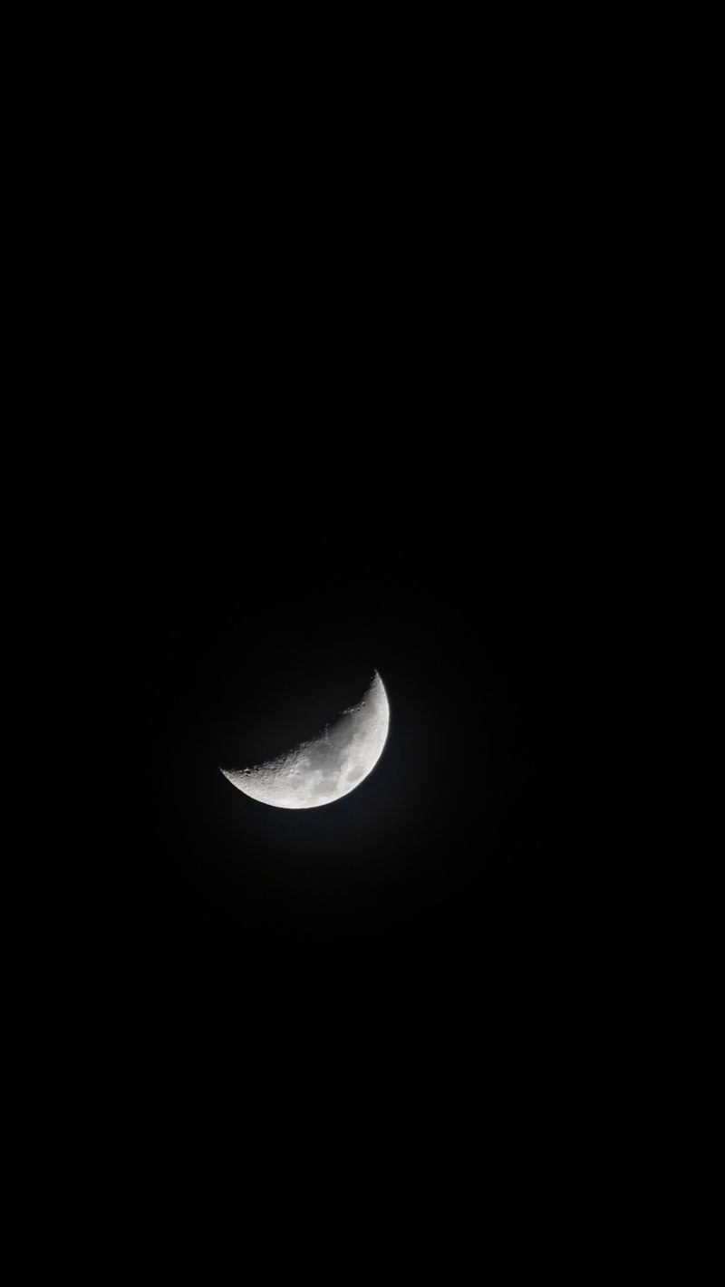 A crescent moon is shown in the dark sky - Moon