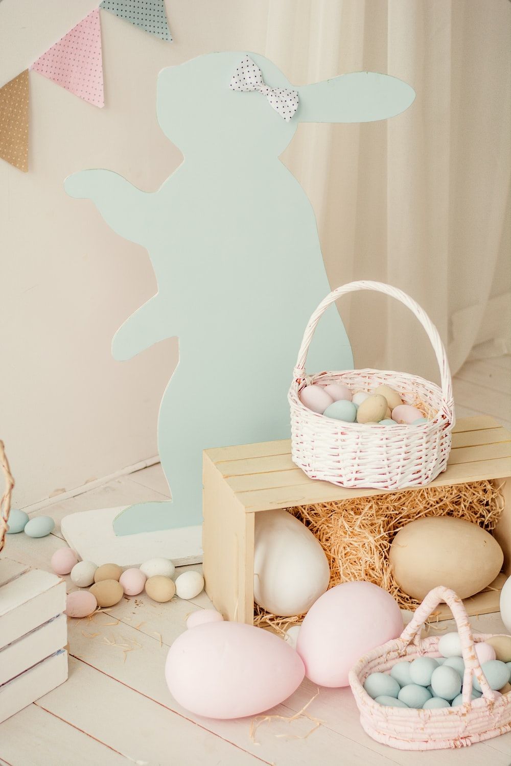 A white basket filled with eggs sitting on top of a wooden crate. - Easter