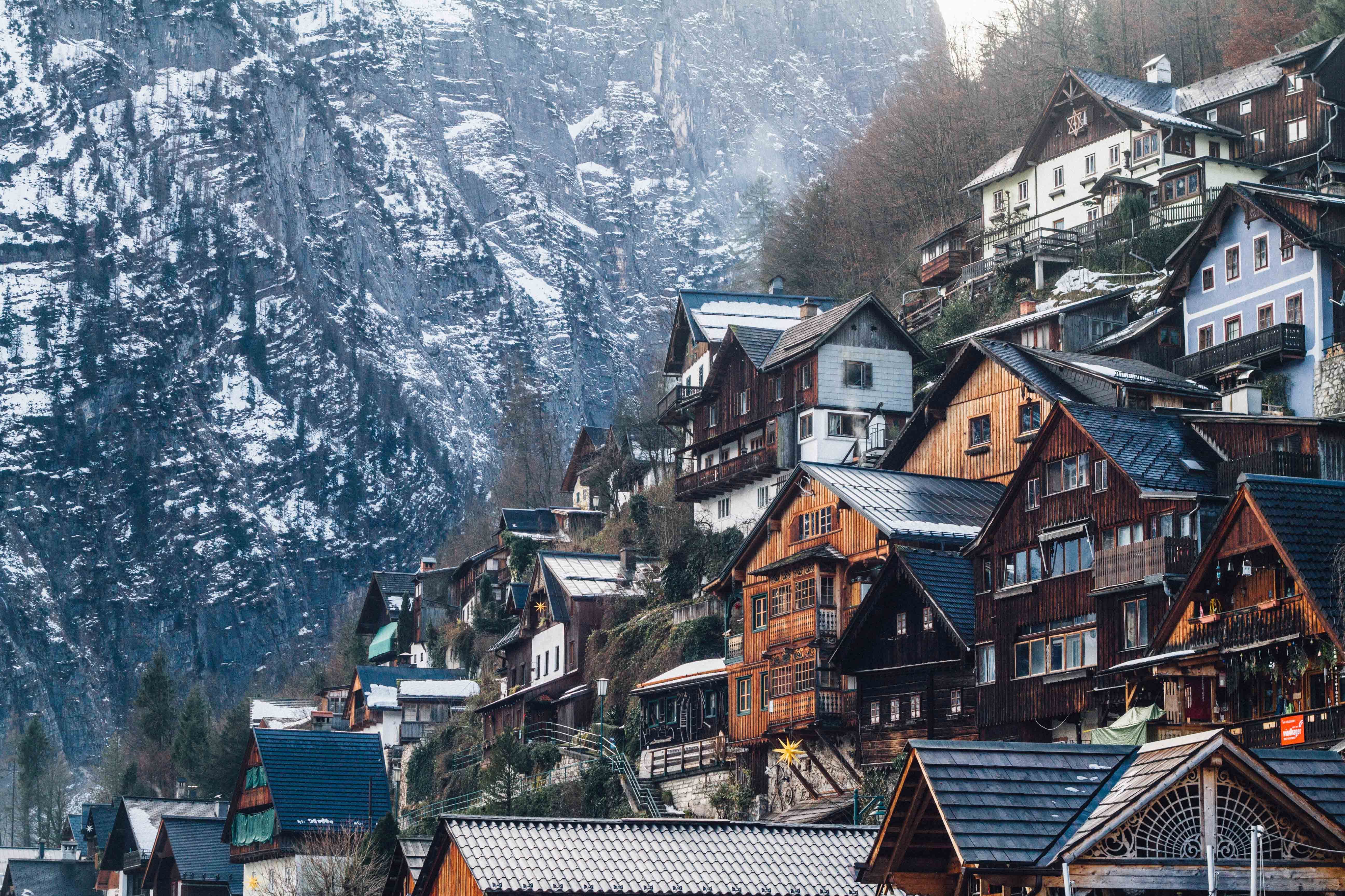 The town of Hallstatt, Austria, is nestled in a valley and surrounded by mountains. - Snow