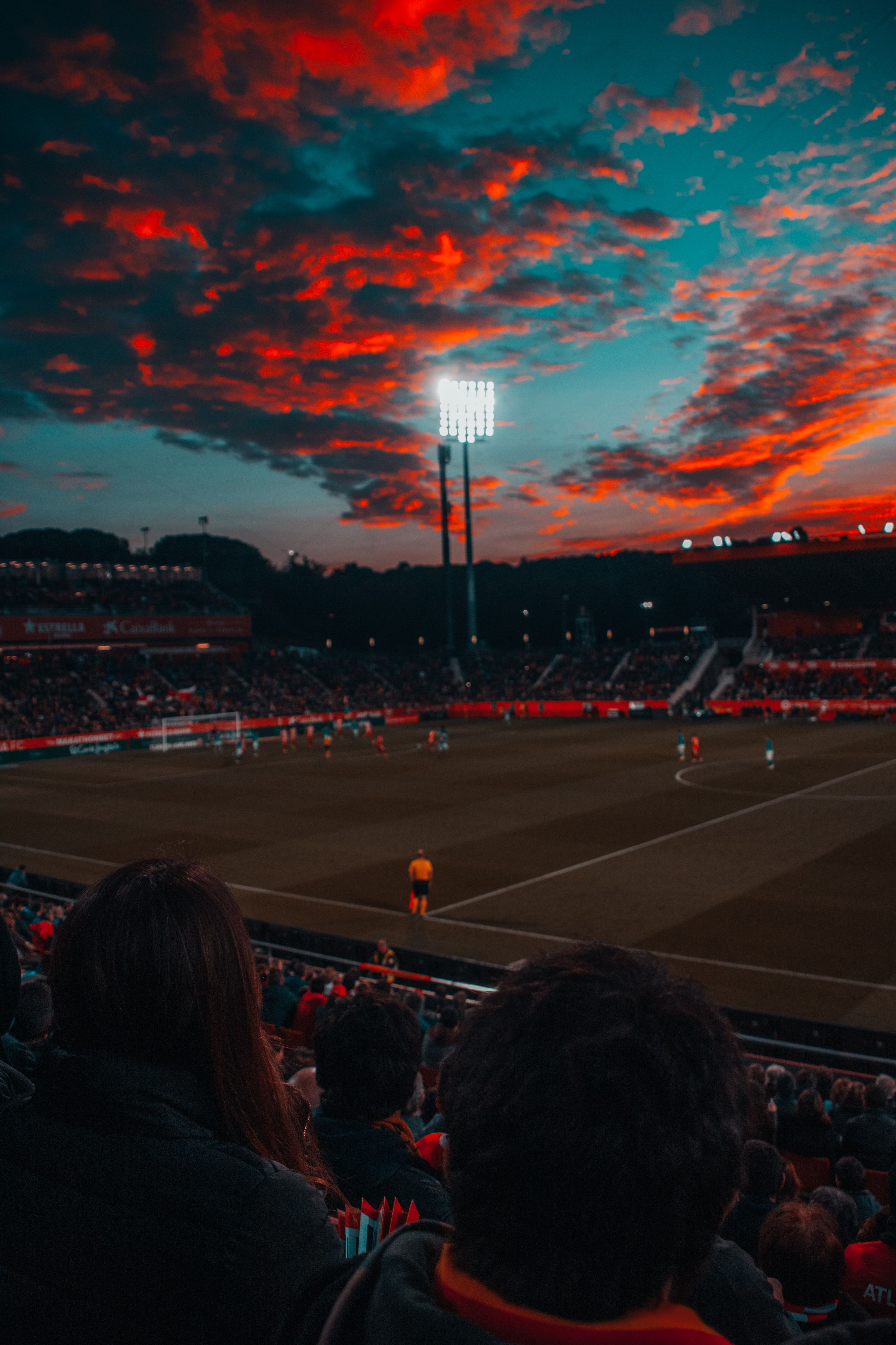 A soccer game is being played at night with the stadium lights illuminating the field. - Soccer