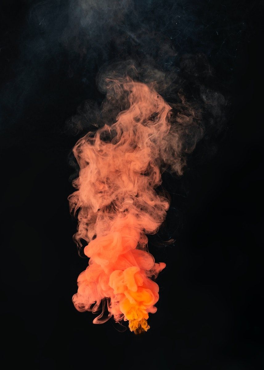 A photograph of a cloud of orange and pink smoke against a black background - Smoke