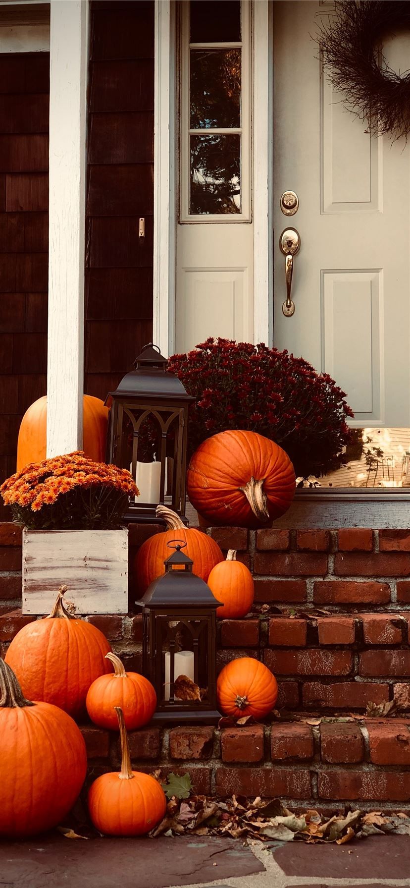 A porch with pumpkins, flowers, and a lantern. - Pumpkin
