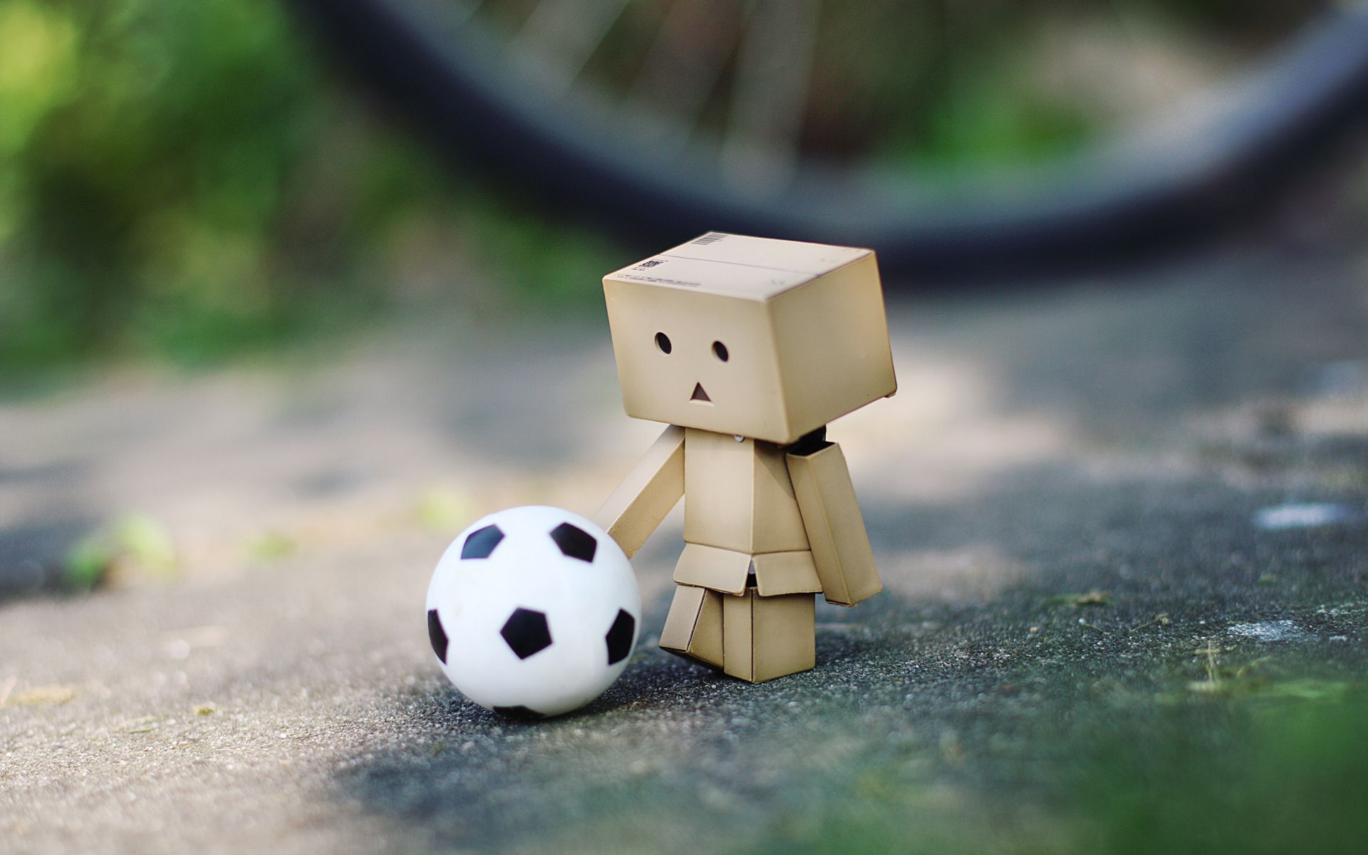 A little toy is standing next too the ball - Soccer