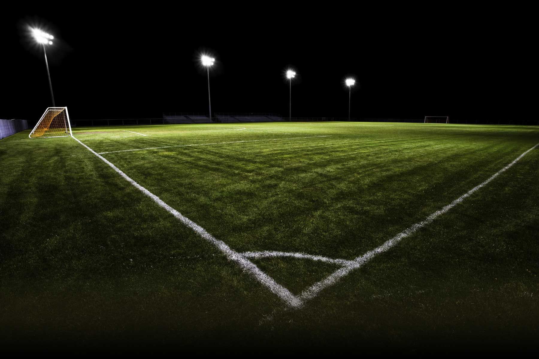 A soccer field with lights on it at night - Soccer
