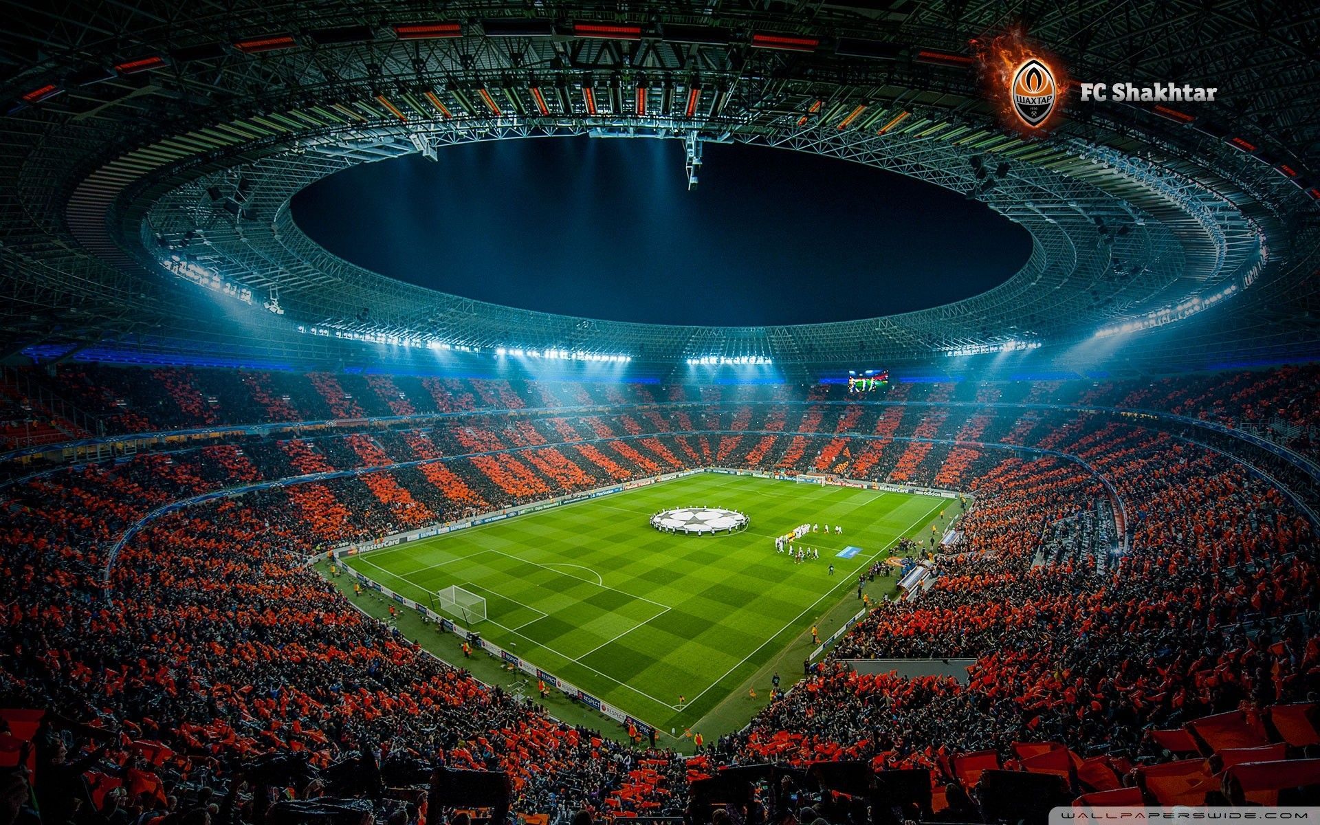 A soccer stadium with orange seats and lights - Soccer