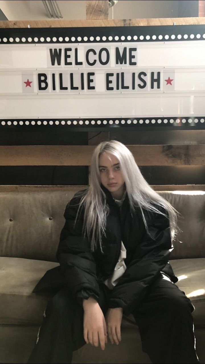 A woman sitting on the couch with her hair in front of billie elish - Billie Eilish