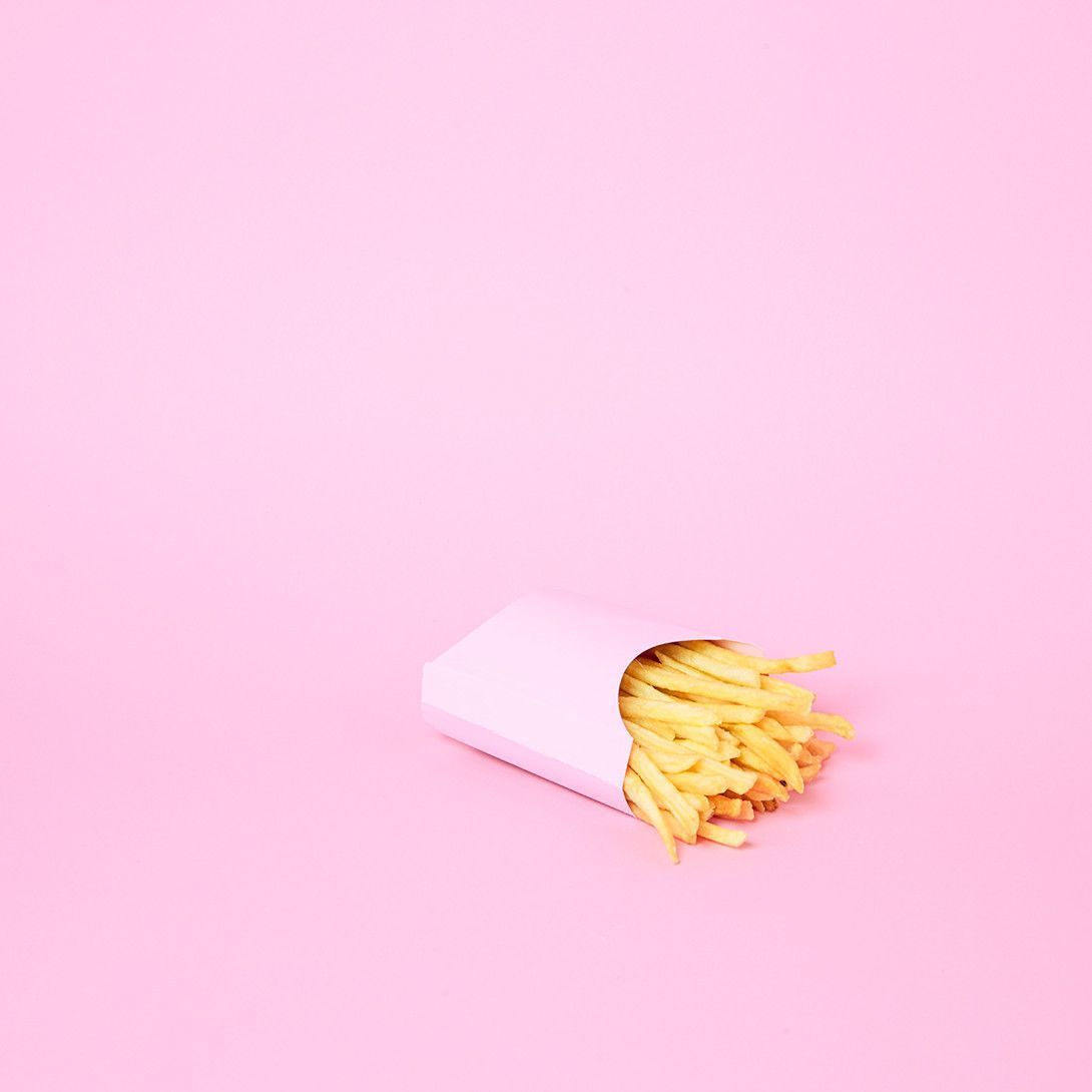 A small white box of french fries on a pink background - Food, foodie