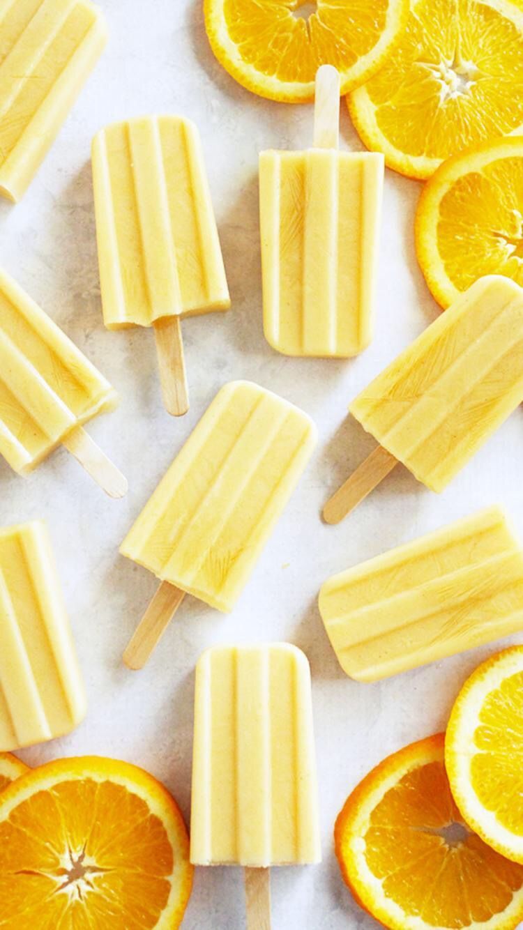 A bunch of popsicles sitting on top an orange - Food