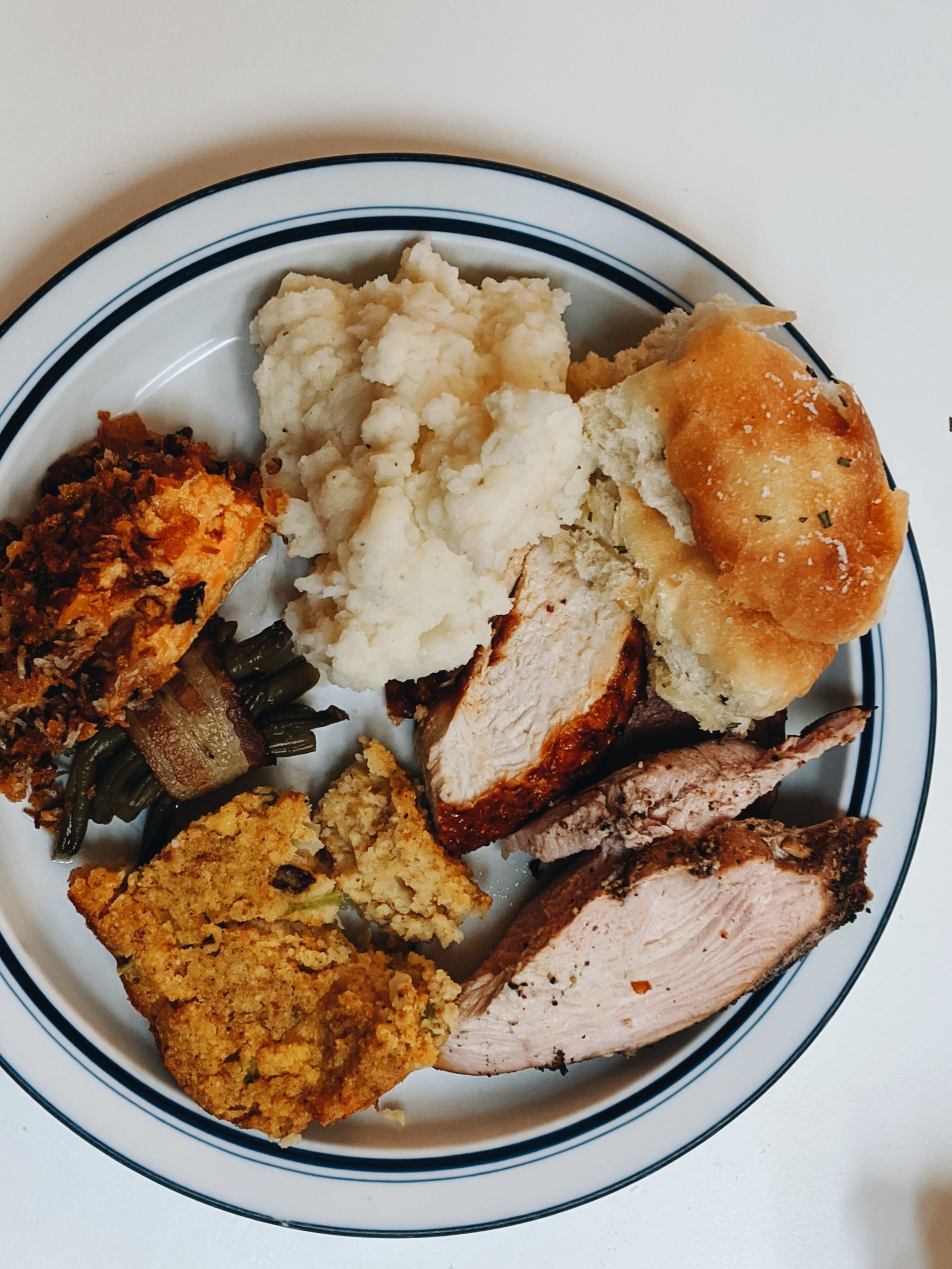 A plate of food including turkey, stuffing, mashed potatoes, and rolls. - Food, foodie